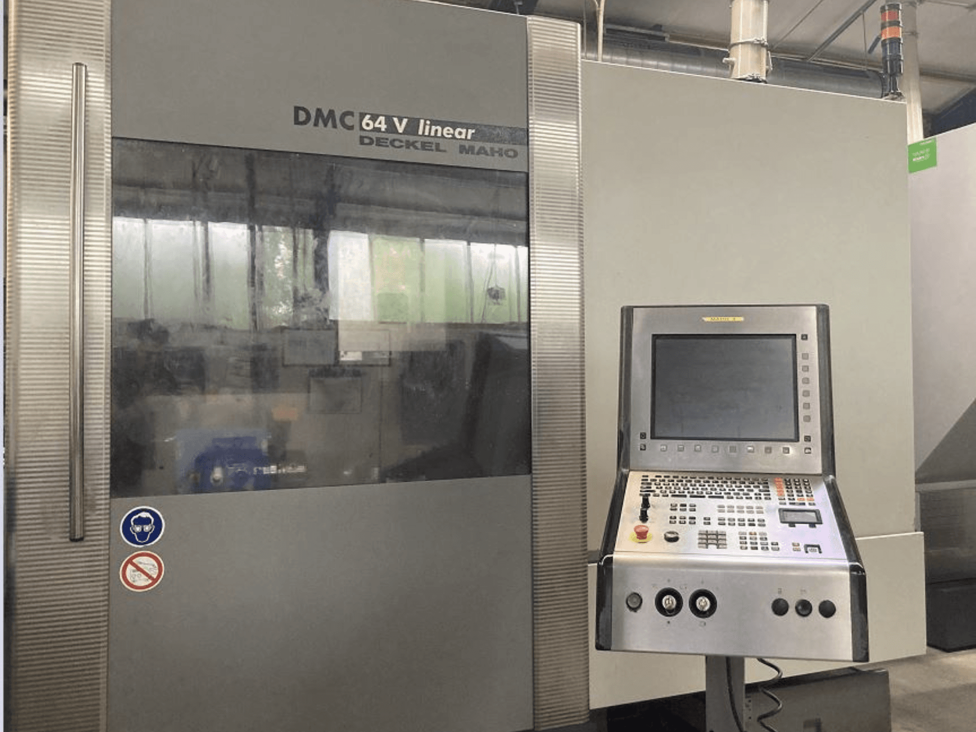 DMG DECKEL MAHO DMC 64V doğrusal dikey işleme merkezi, kontrol paneli ve ekranı gösteren önden görünüm.