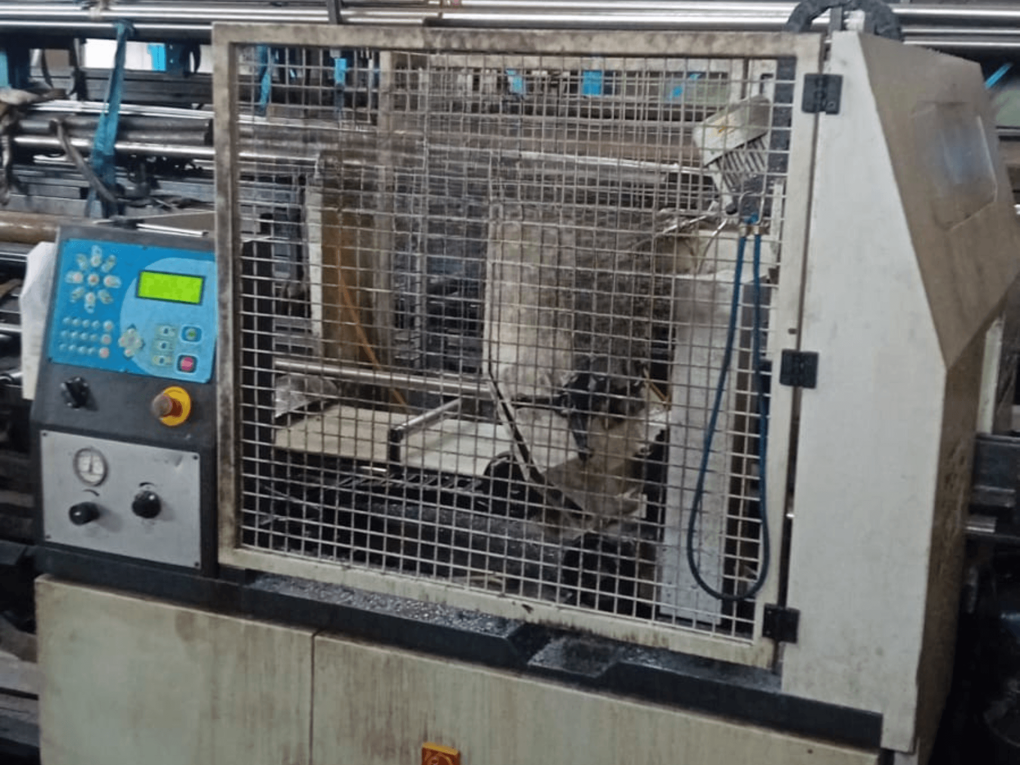 Metal Şerit Testere Macc 381 AV, önden görünüm, kontrol panelini, güvenlik kafesini ve tabandaki metal işçiliği kalıntılarını gösteriyor.