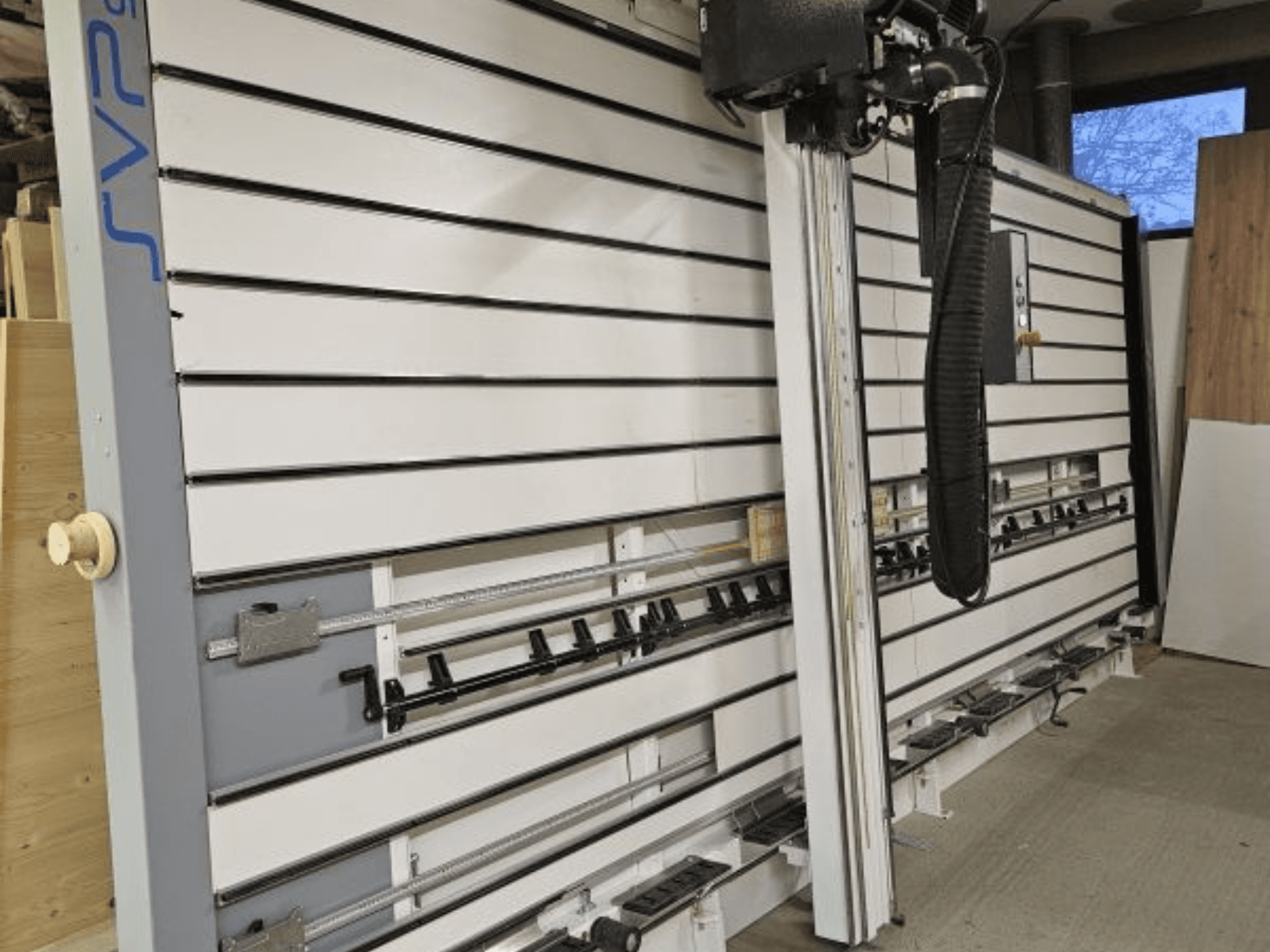 Atölyede SVP kayar panel testere, önden görünüm, ayarlanabilir paletler ve baş üstü toz emme sistemi.