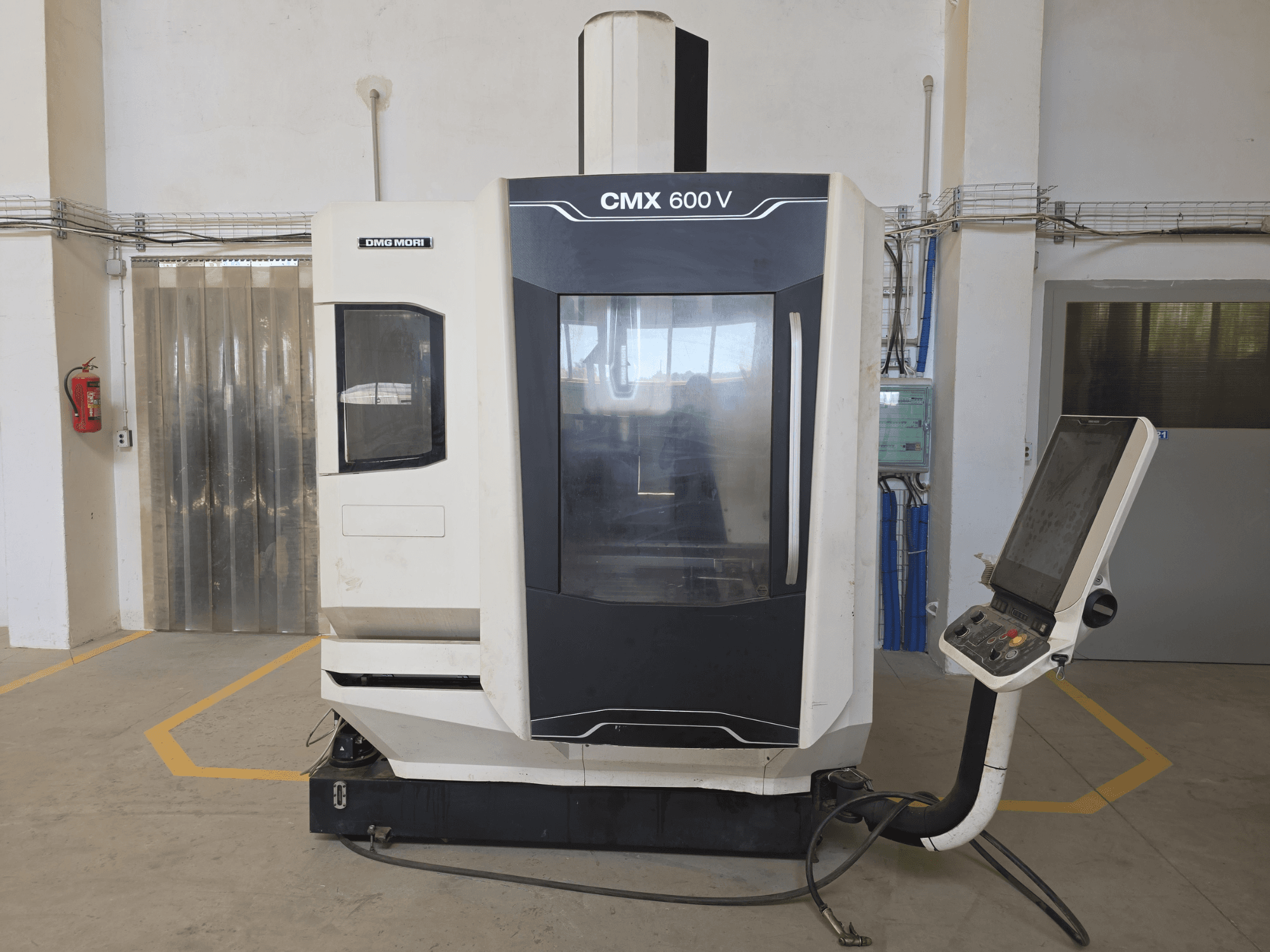 DMG MORI CMX 600 V dik işleme merkezi, önden görünüm, kontrol paneli ve büyük şeffaf pencere.