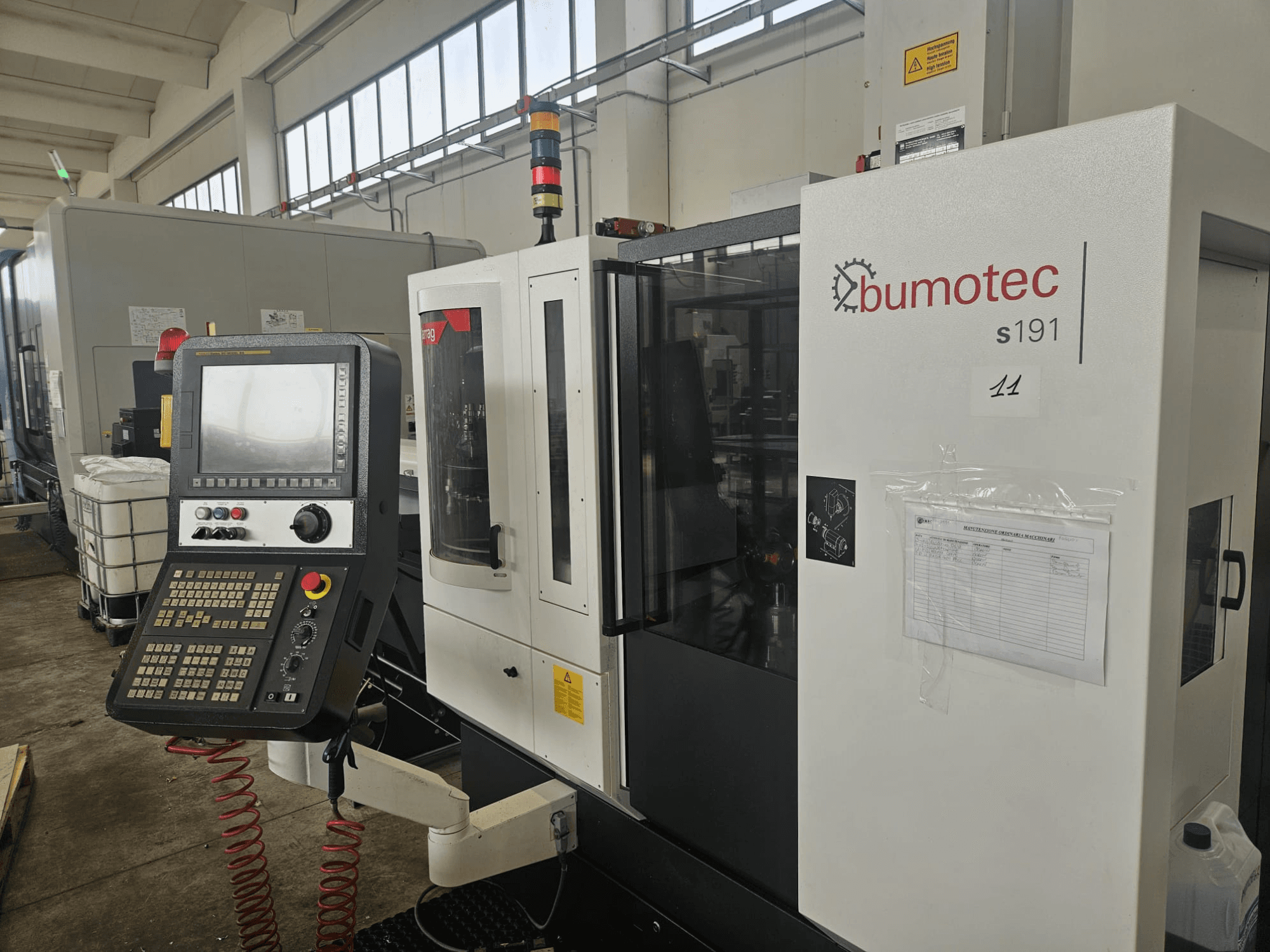 Bumotec s191 Turn-Mill Center önden görünüm, fabrika ortamında kontrol paneli ve çalışma etiketleri.