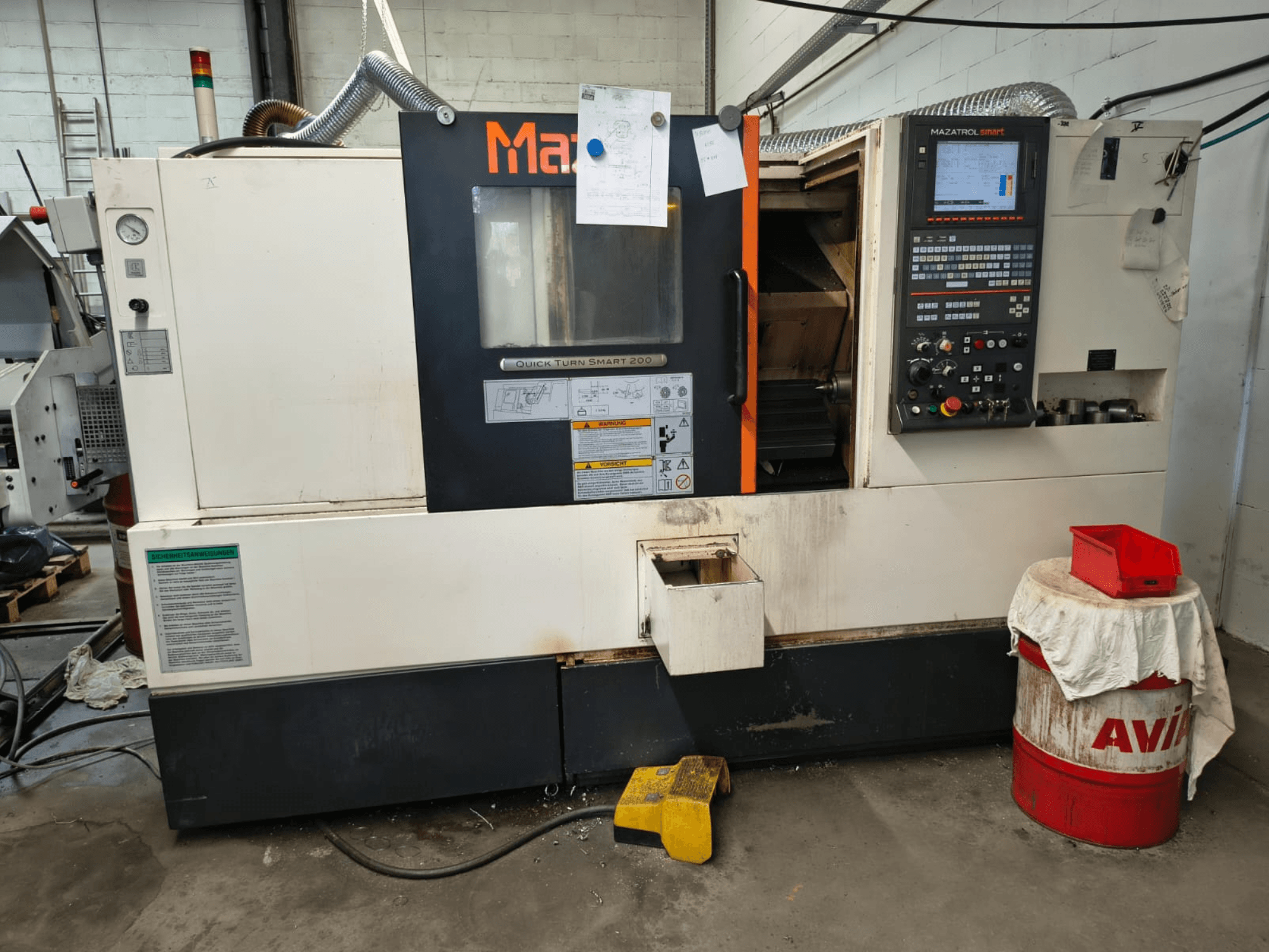 Mazak Quick Turn Smart 200, yatay torna tezgahı; kontrol paneli, soğutma sıvısı deposu ve işaretlemelerin görüldüğü önden görünüm.
