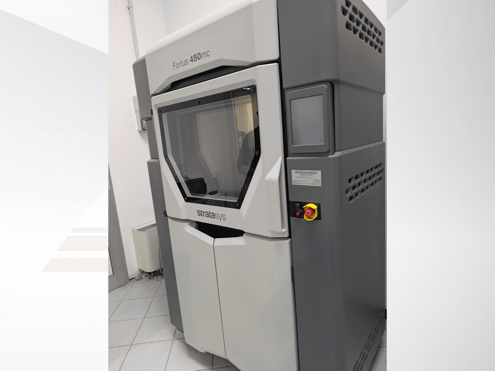 Yan görünümde gösterilen Fortus 450mc plastik 3D yazıcı, şeffaf bir ön panele ve yan tarafta kontrol düğmelerine sahiptir.
