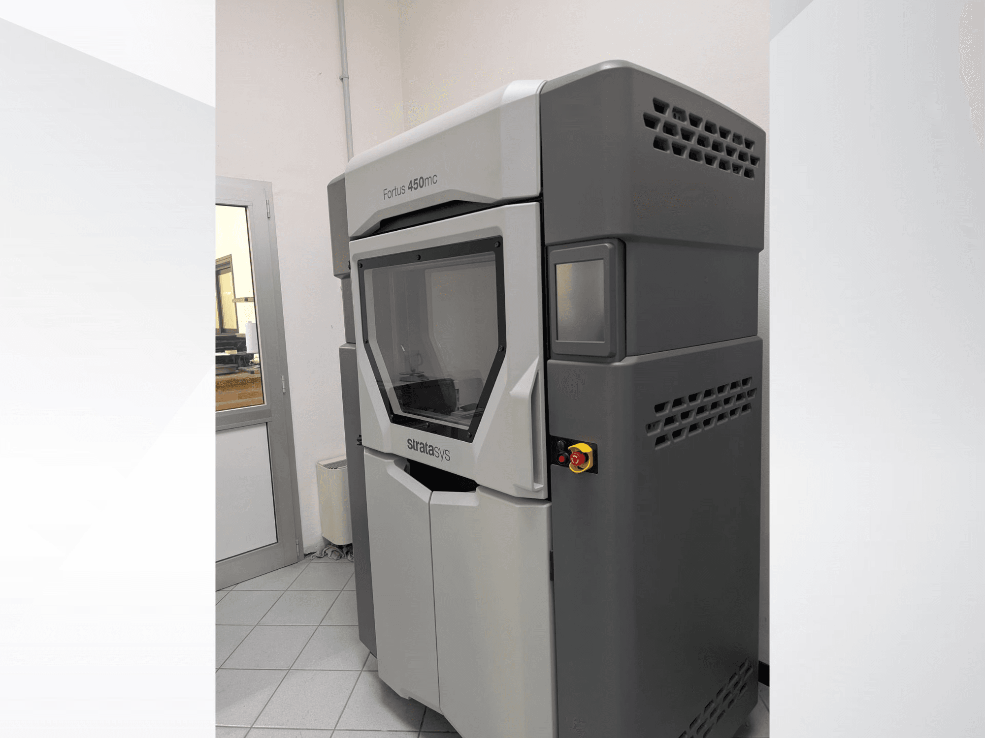 Stratasys FORTUS 450mc plastik 3D yazıcı, şık bir tasarım ve kontrol paneli sergileyen yandan görünümde.