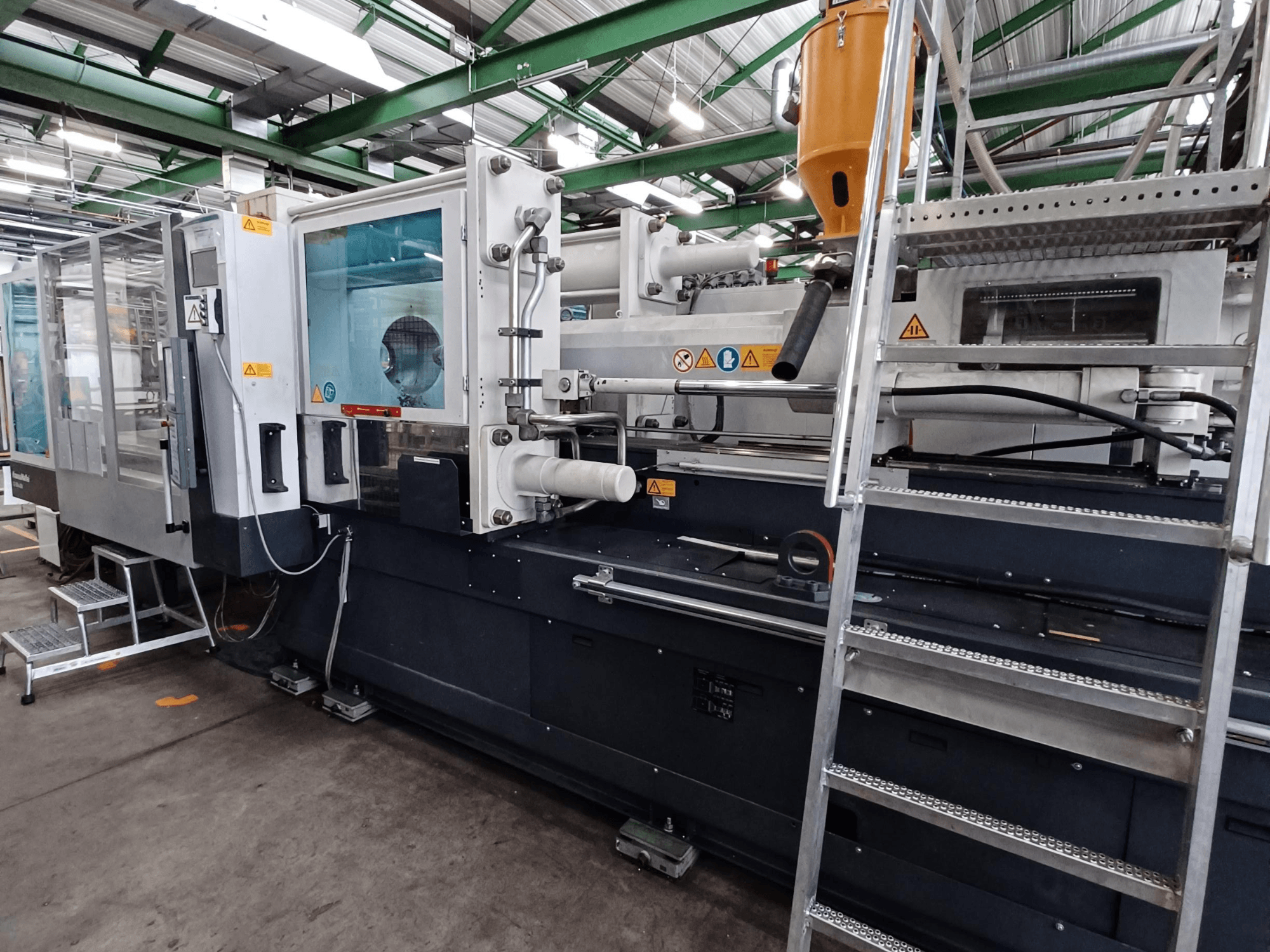 Marka işaretlerini, kontrol panelini ve malzeme haznesini gösteren net bir ön görünüme sahip endüstriyel enjeksiyon kalıplama makinesi.