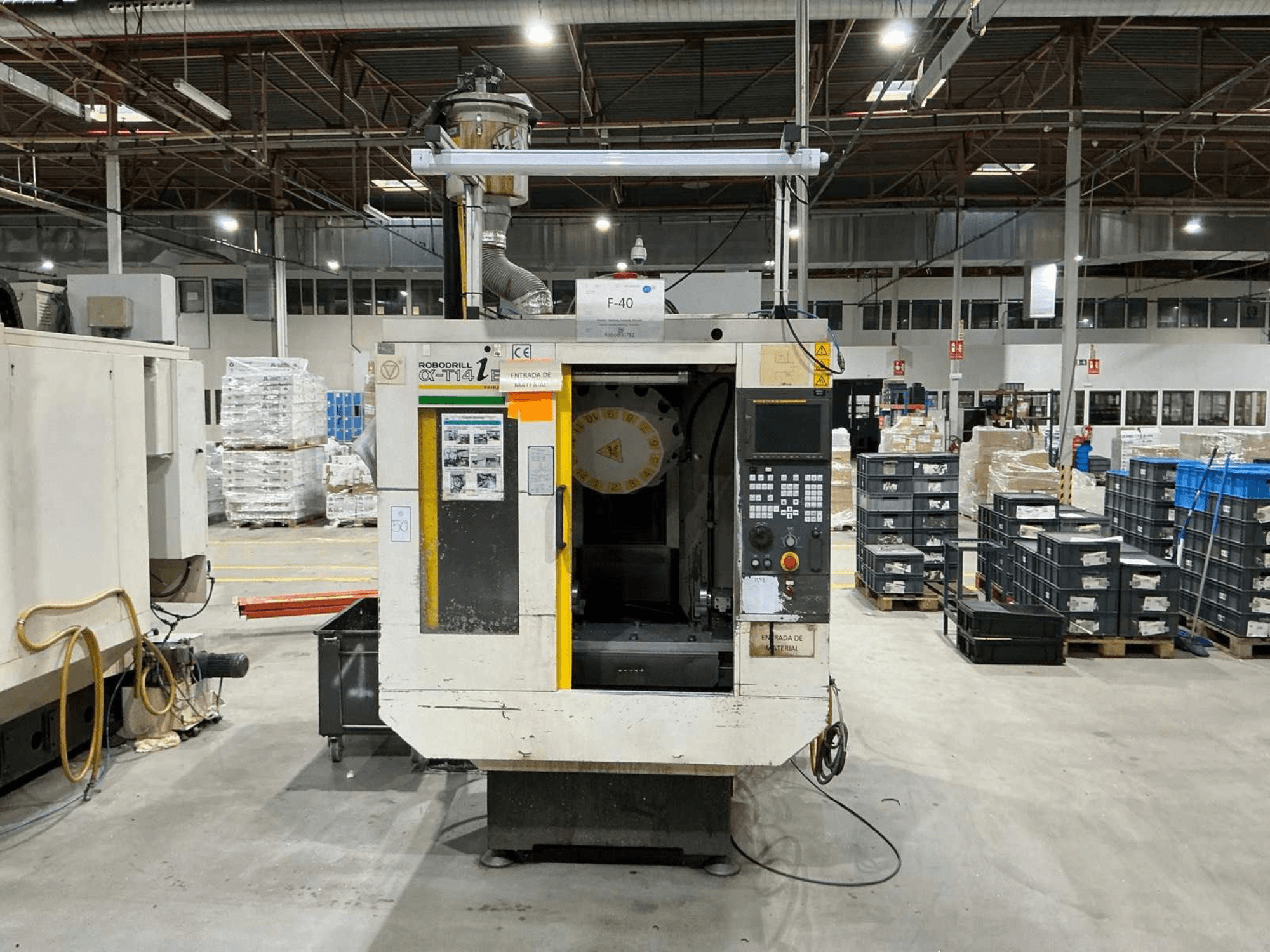 Fabrikadaki FANUC ROBODRILL α-T14iB dikey işleme merkezi, kontrol paneli ve takım tutucuyu gösteren önden görünüm.