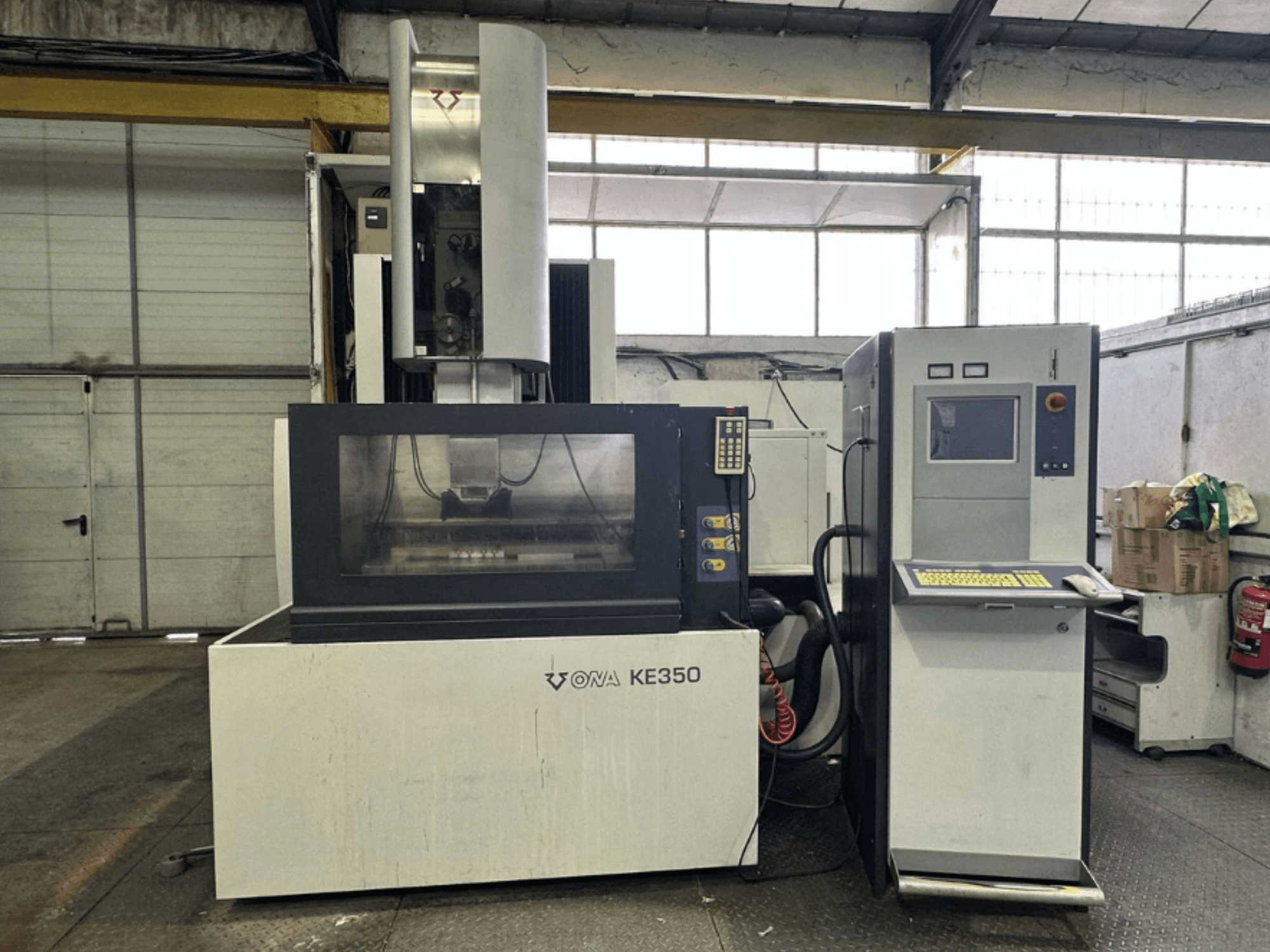 Endüstriyel bir ortamda bulunan kontrol paneli, ekran ve çeşitli düğmelerle ONA KE350 CNC makinesinin önden görünümü.