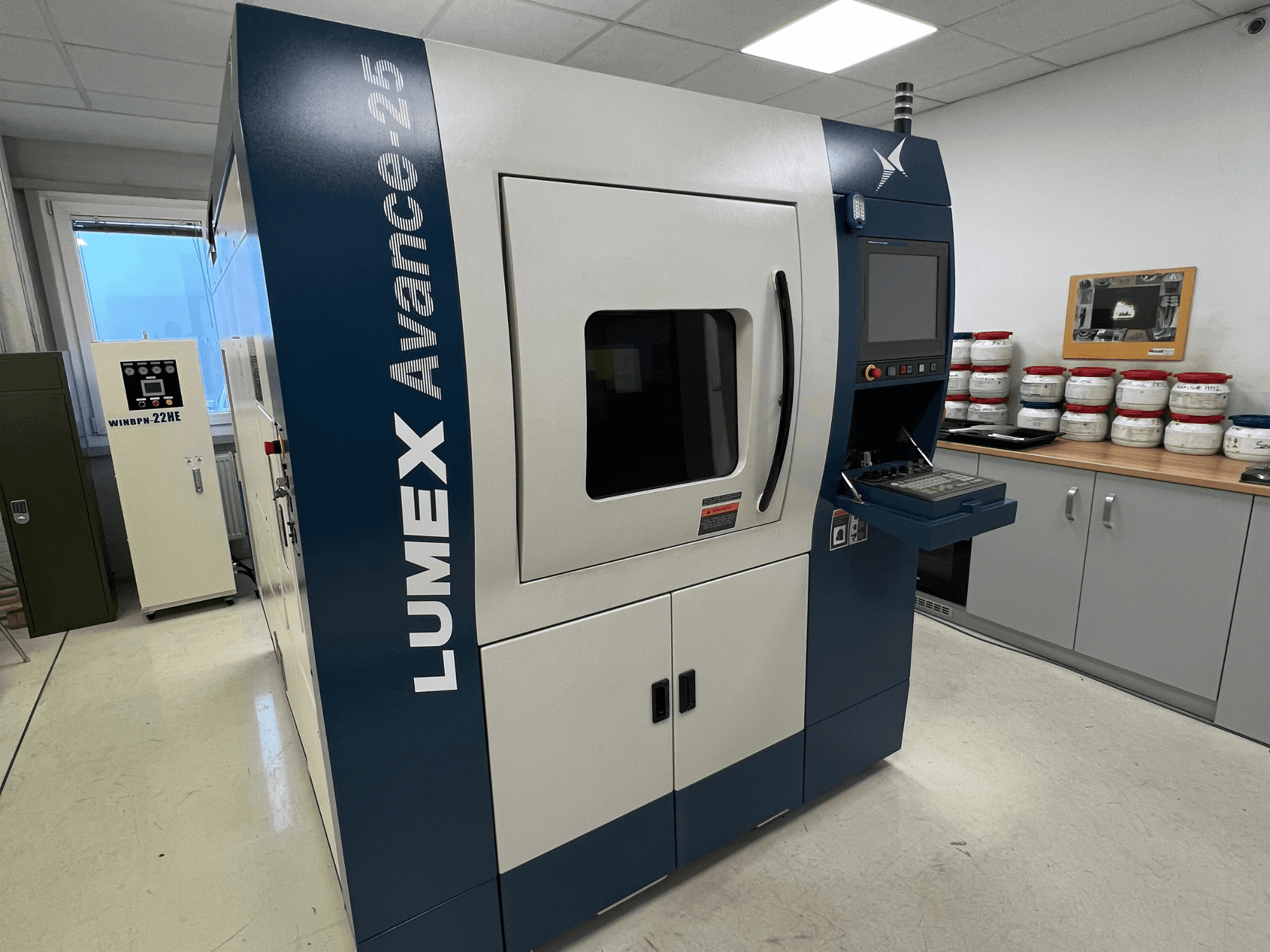 Laboratuvar ortamında LUMEX Avance-25 3D yazıcı, önden görünüm. Ekran ve düğmelerin göründüğü kontrol paneli, arka planda ekipman.