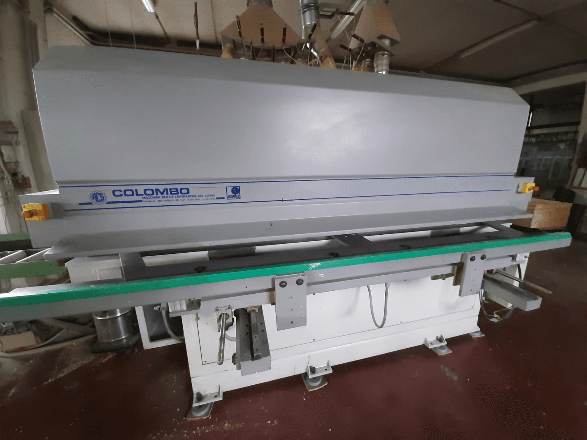 Colombo ahşap işleme makinesi, önden görünüm, uzun yeşil bir tabla, kontrol düğmeleri ve mavi desenli gri bir gövdeye sahip.