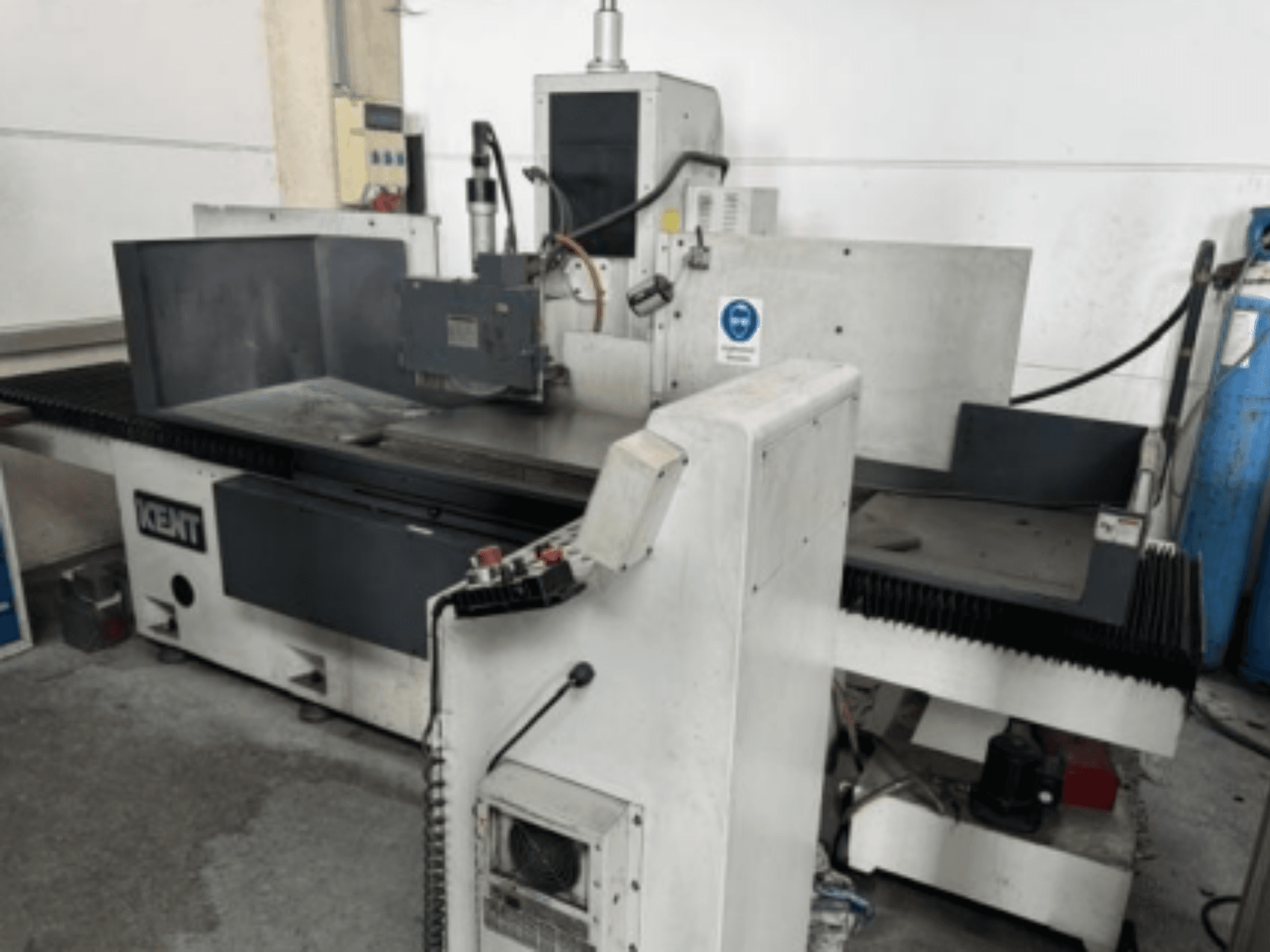 Kent KOS-510V.MA2 yüzey taşlama makinesinin önden görünümü; kontrol paneli ve taşlama alanı görülmektedir.