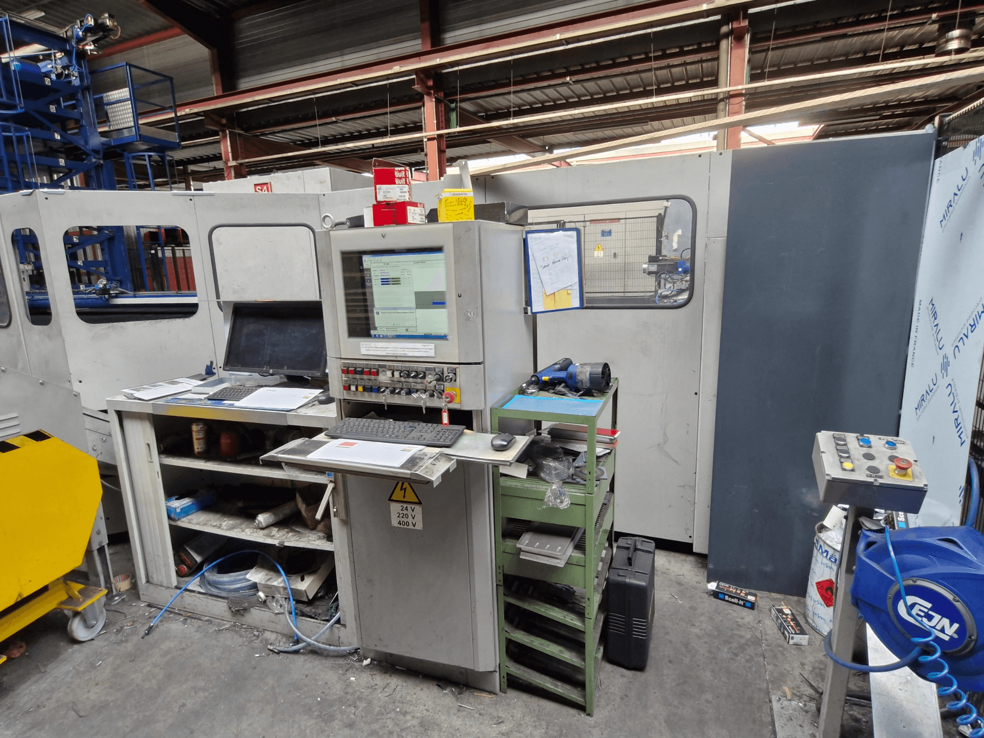 CNC Delme Makinesi Salvagnini S4-40 bir atölyede, monitörler ve aletler içeren bir kontrol paneli, önden görünüm.
