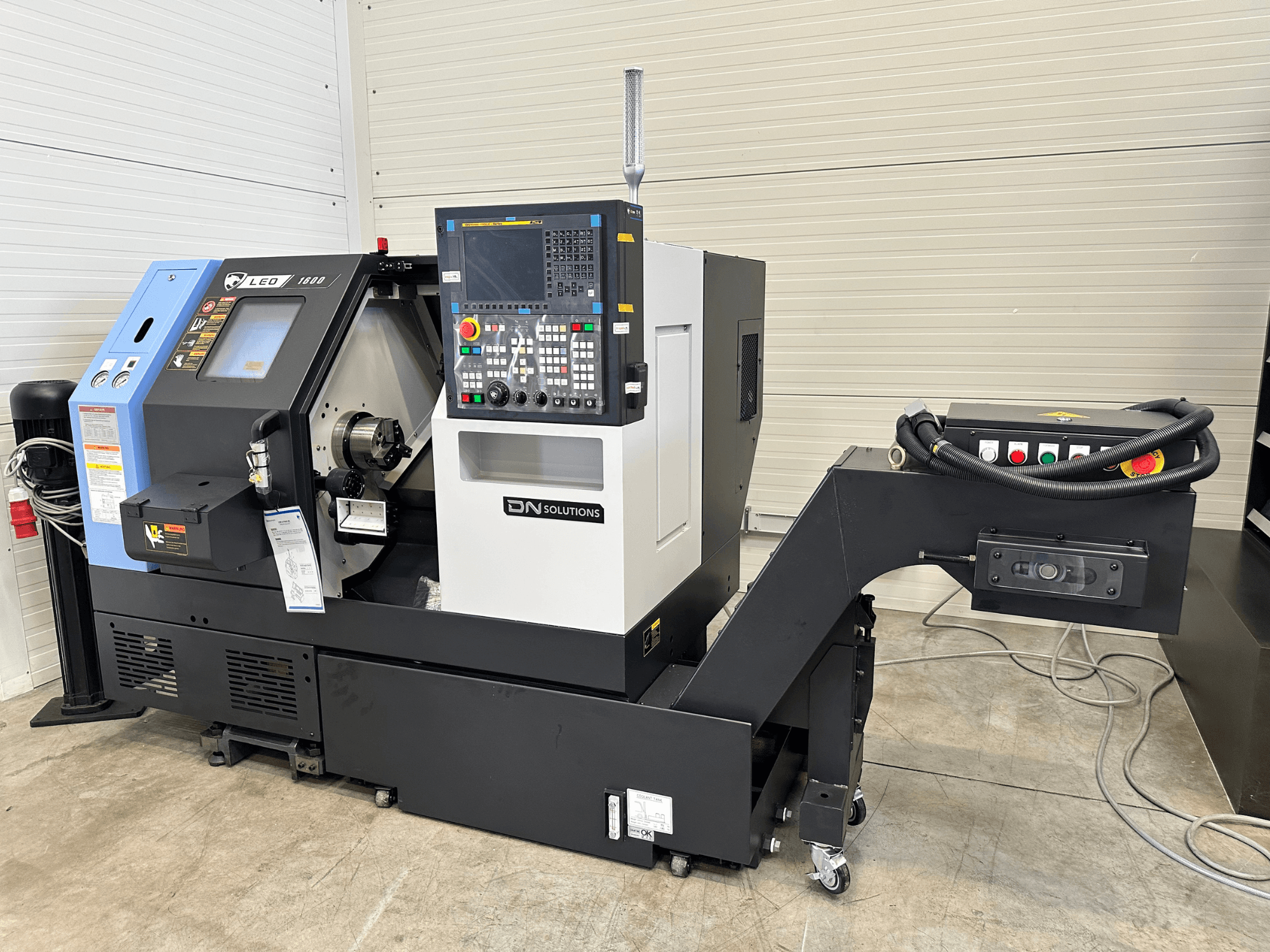 Siyah taban üzerinde dijital kontrol paneli ve takım tutucusu bulunan DN SOLUTIONS Leo 1600 torna freze merkezinin önden görünümü.