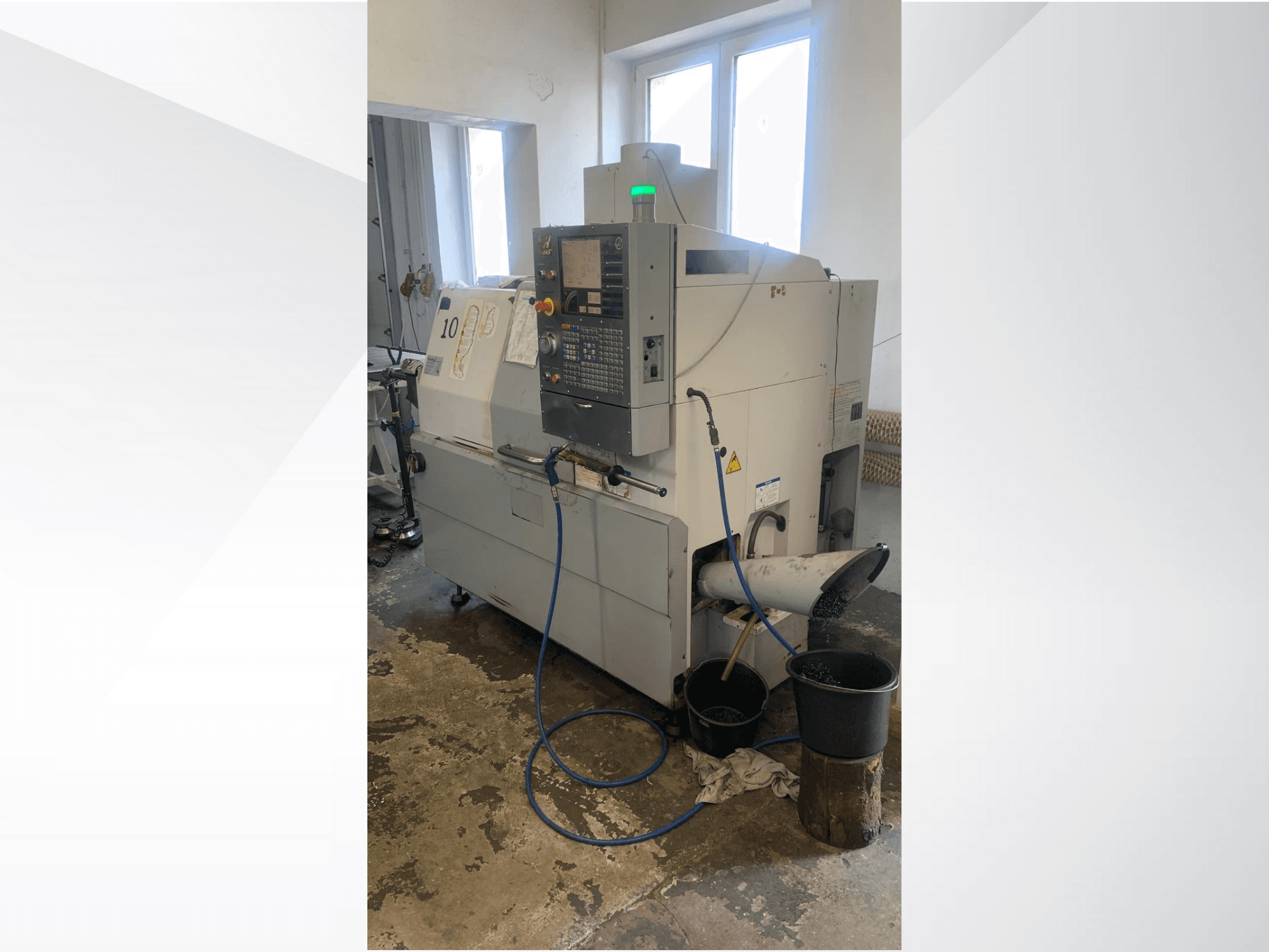 Kontrol panelli Haas CNC makine modeli, yandan görünüm, soğutma sıvısı hattı, atık oluğu ve altındaki saklama kapları.