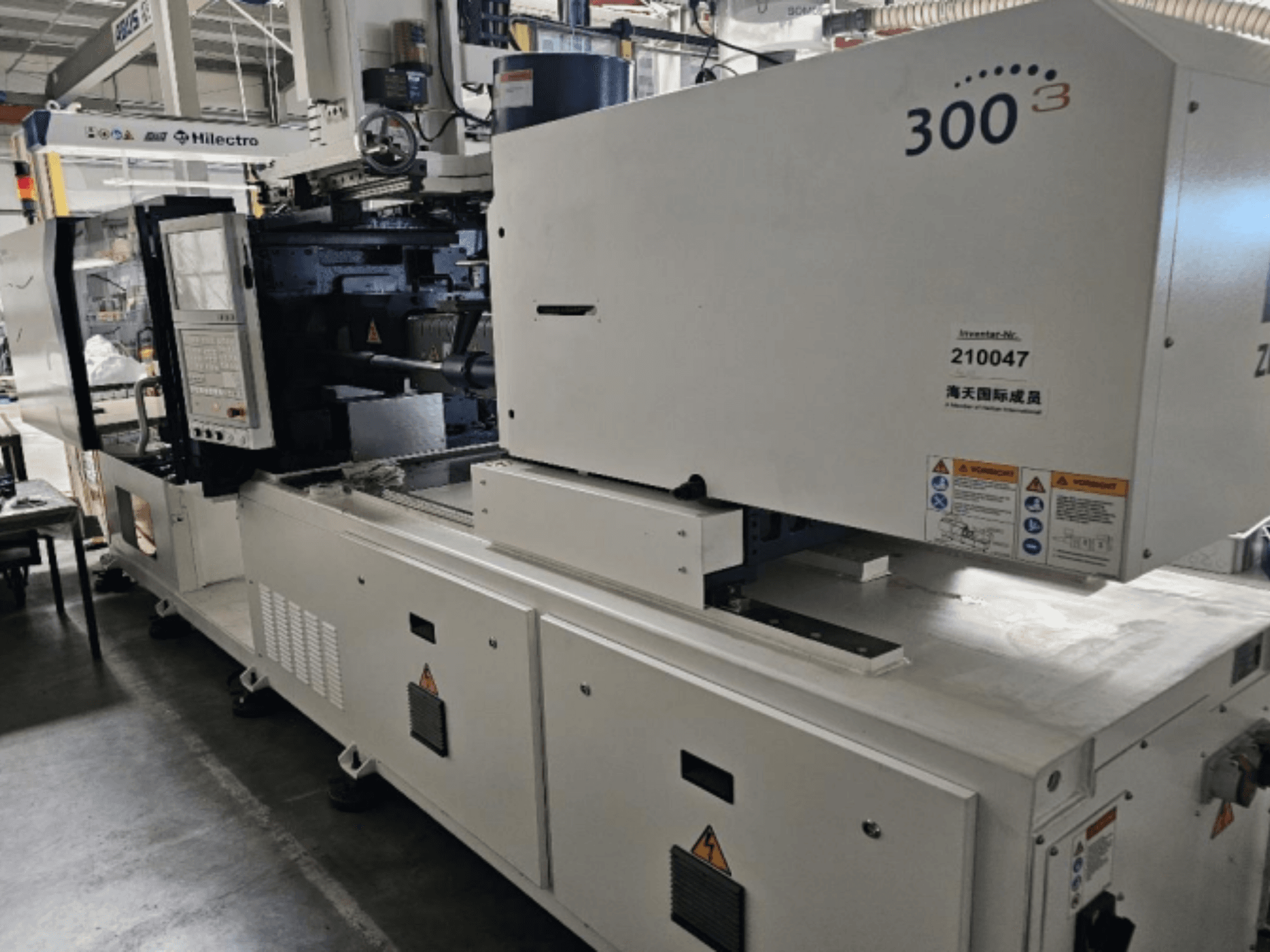 Enjeksiyon kalıplama makinesi, marka Zhenjing, model 300, kontrol paneli ve güvenlik uyarı etiketleri görünür şekilde önden görünüm.