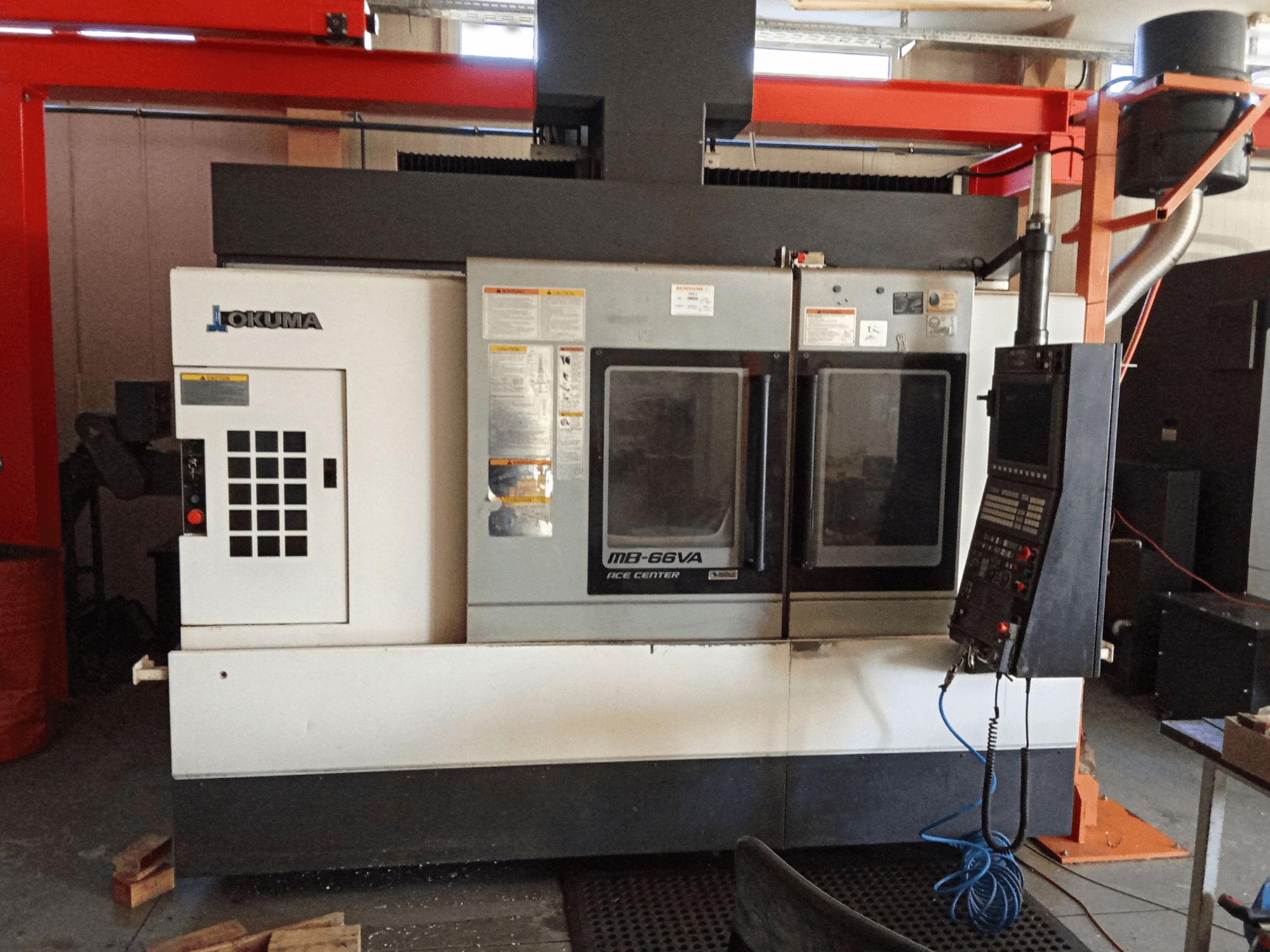 Okuma MB-66VA dikey işleme merkezi, kontrol panelini ve takım erişimi için çift görüntüleme pencerelerini gösteren önden görünüm.