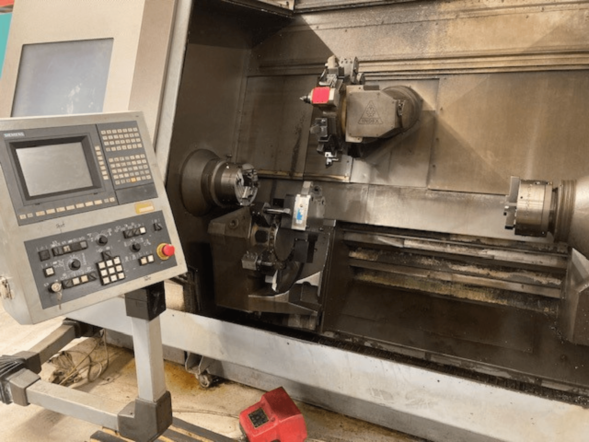 Kontrol paneli, görünür ayna ve çalışma alanı ile yatay tornalama makinesi Index G300 L YB, önden görünüm.