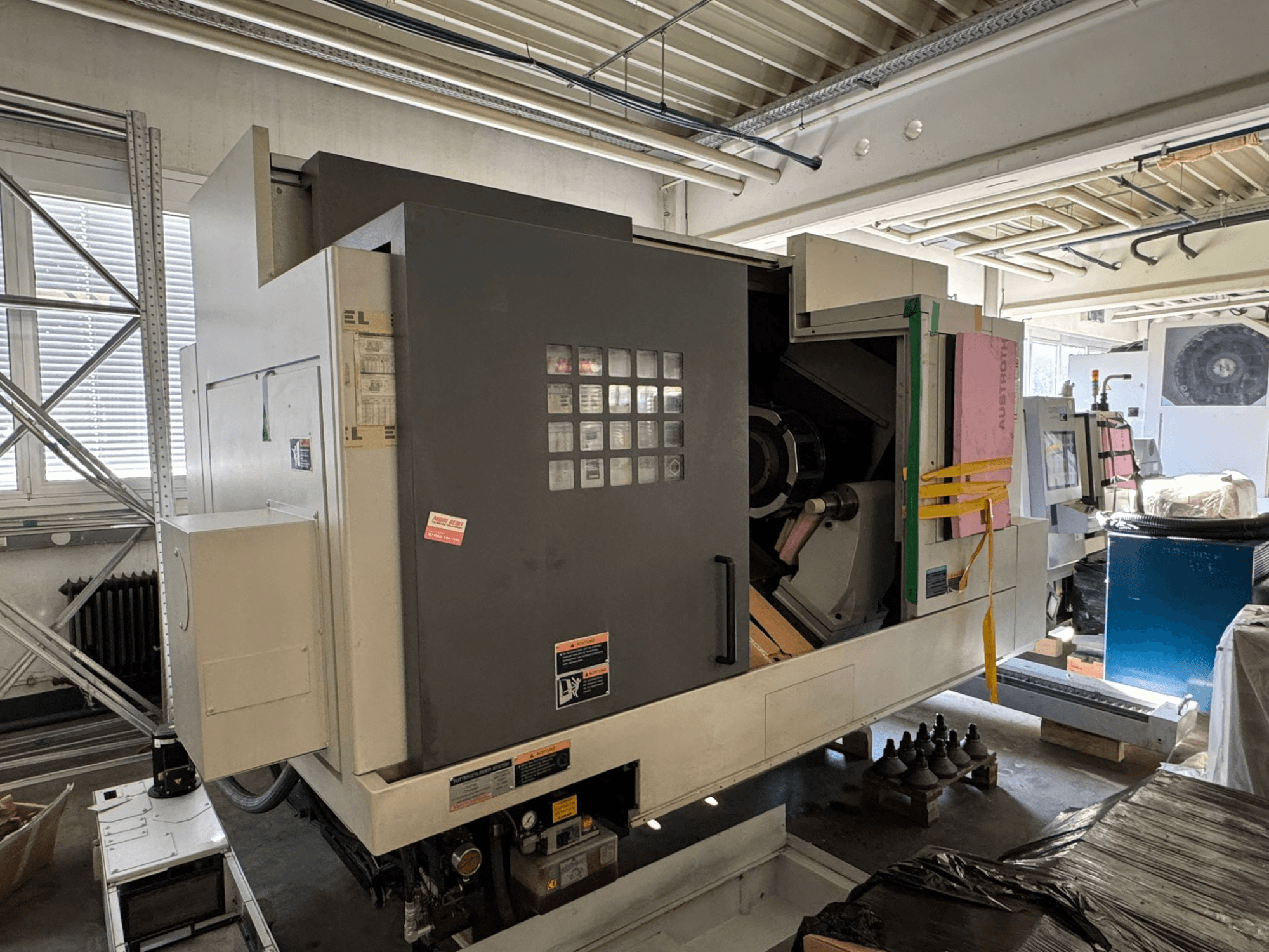 MORI SEIKI NL 3000 MC/700 yatay torna tezgahı; kontrol paneli, depolama alanı ve koruyucu kılıfın bulunduğu önden görünüm.