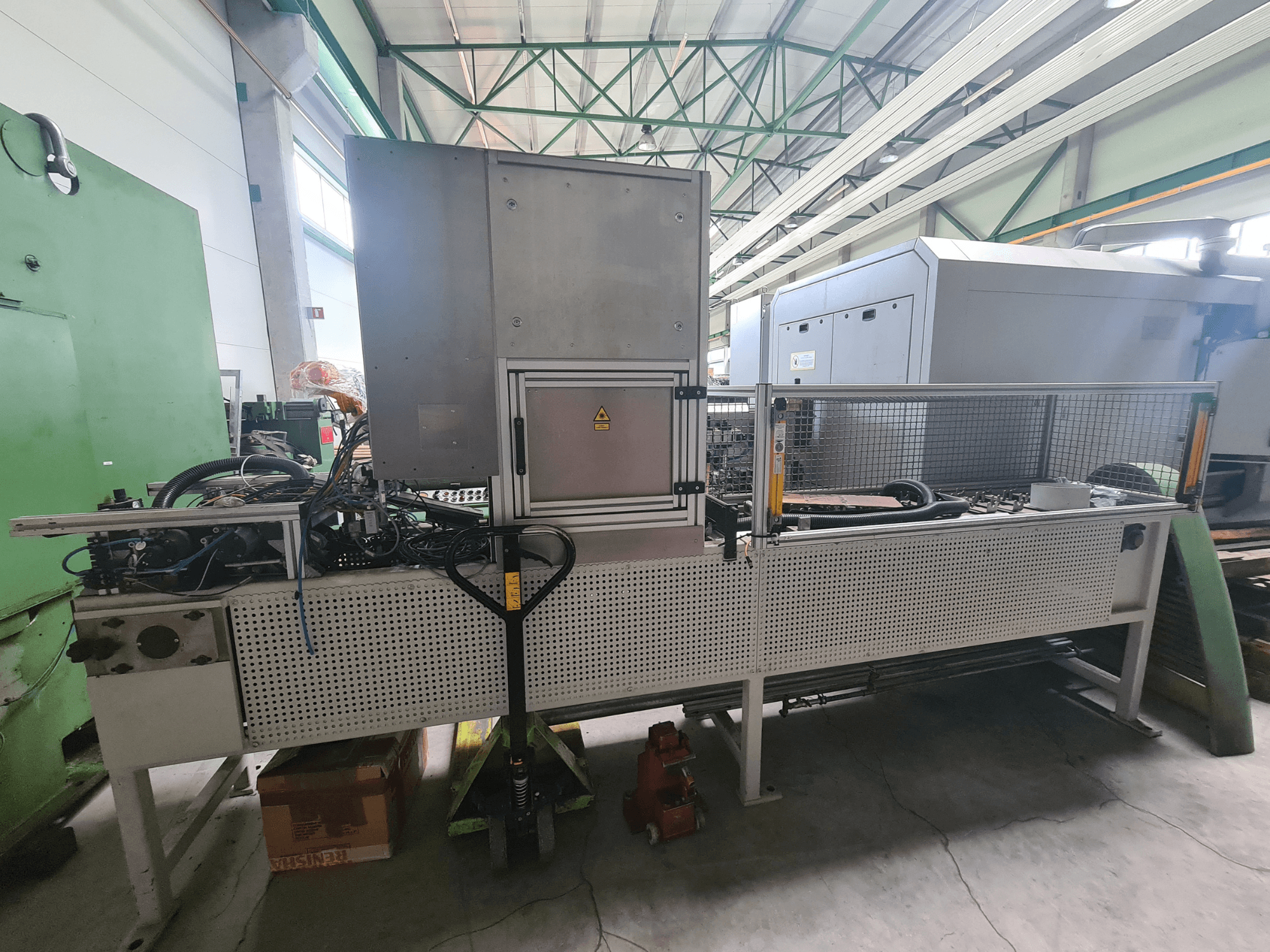 Fabrika ortamında yandan bakıldığında metal çerçeveli, hortumlu ve kontrol panelli endüstriyel makine.