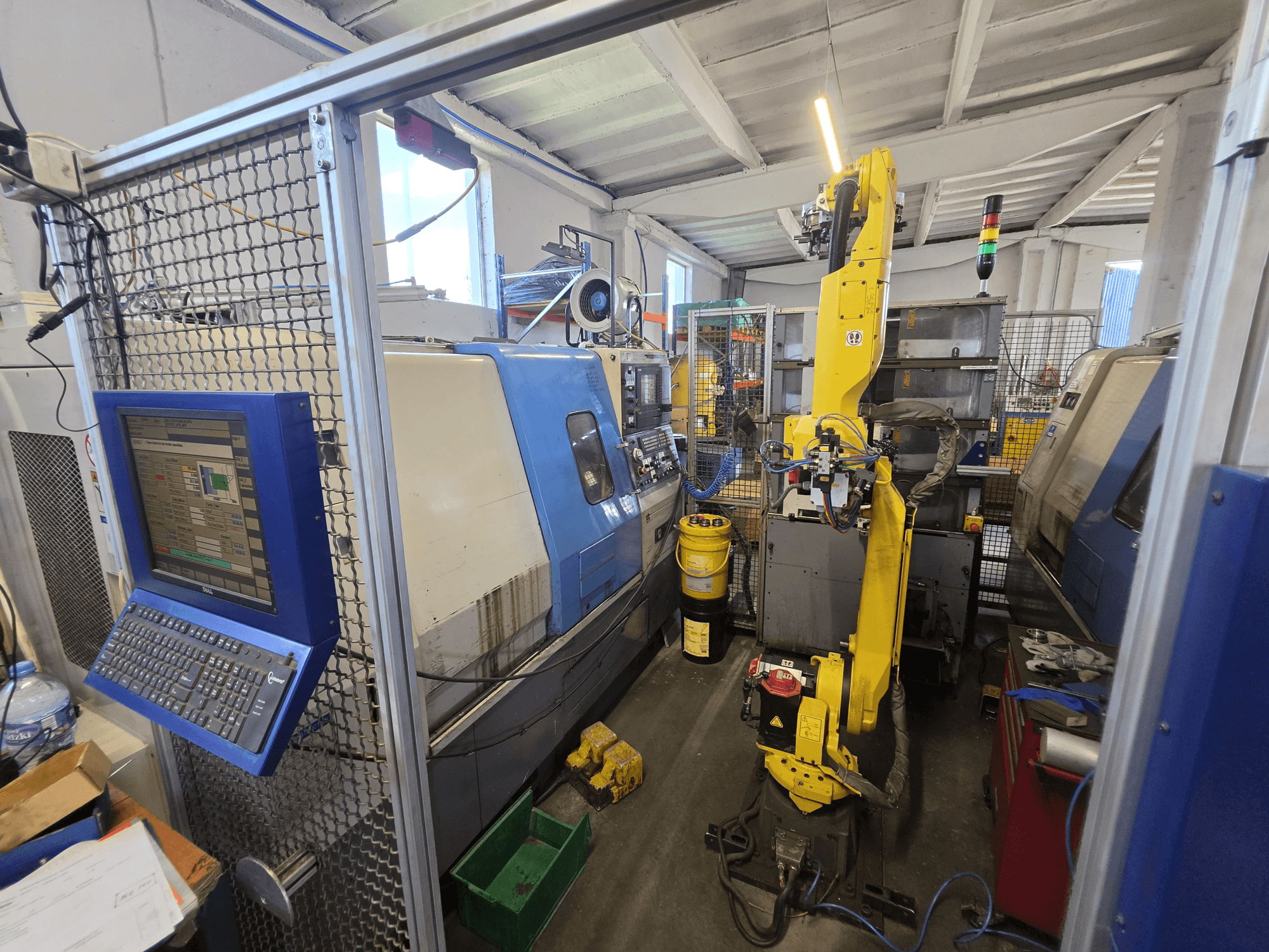 FANUC M-20iA robotlu Hyundai HIT-200C yatay torna tezgahı; kontrol arayüzünü ve makine düzenini gösteren önden görünüm.