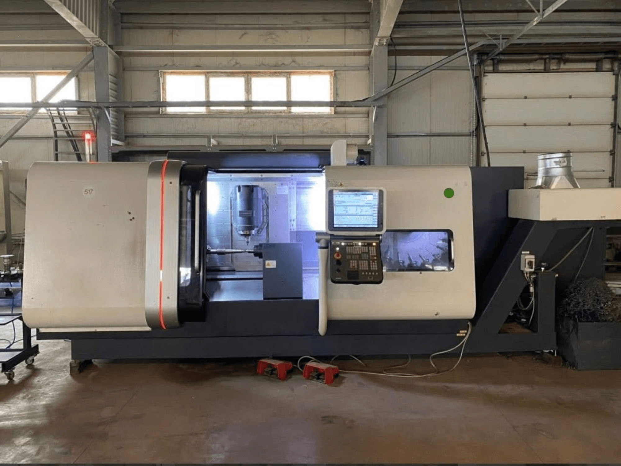 DMG MORI Beta 1250 TC torna freze merkezi, kontrol paneli ile önden görünüm, aydınlatılmış çalışma alanı ve kesme takımları görünür.