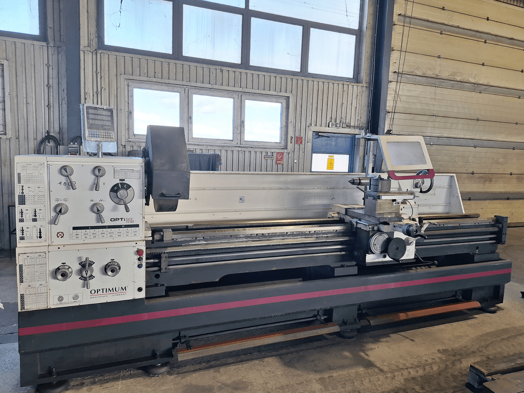 Optimum OptiTurn TH 8030D yatay tornalama makinesinin yandan görünümü, kontrol paneli, takım tutucusu ve sağlam tabanı.