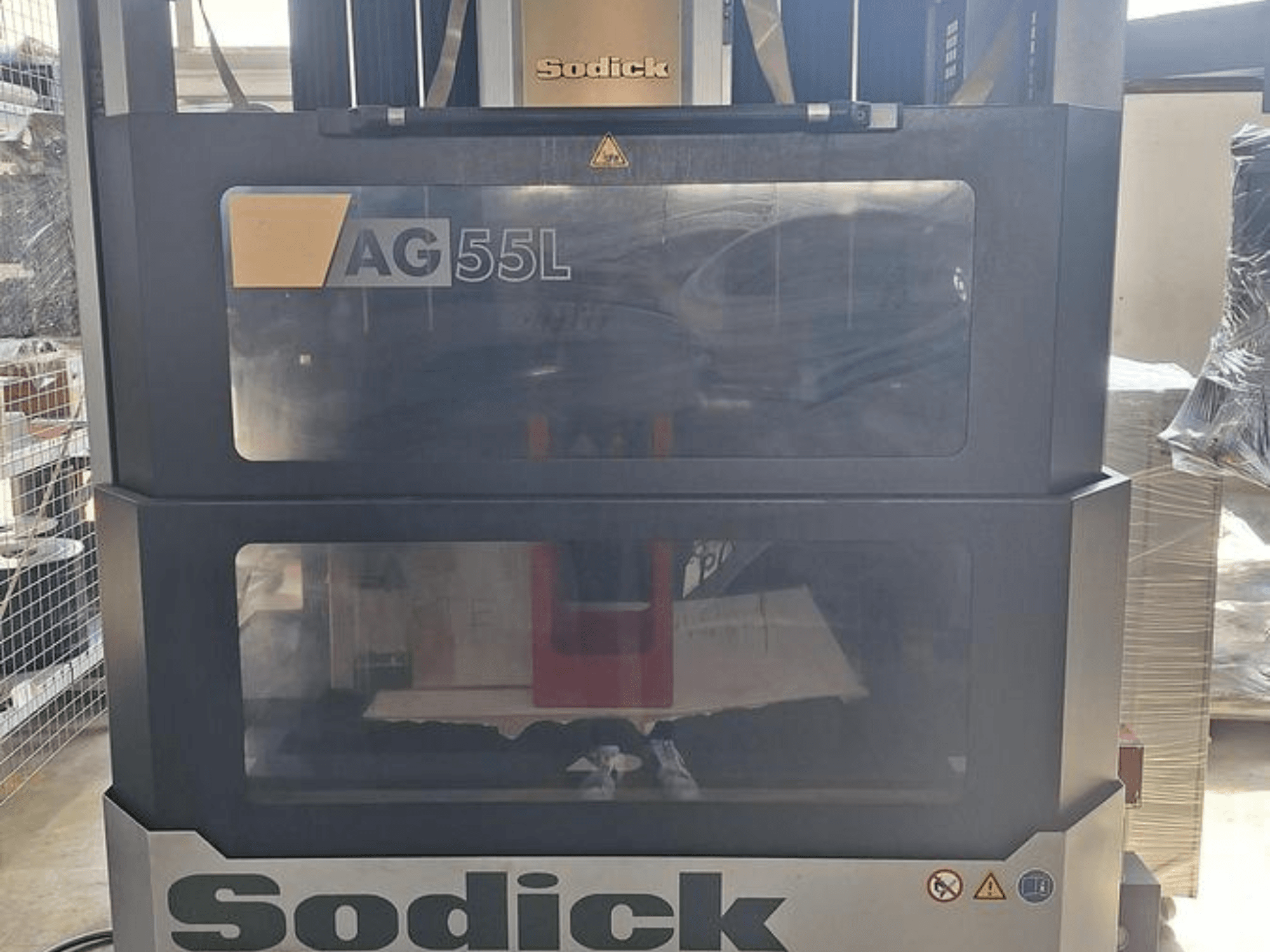 Sodick AG 55L Die-Sinking EDM Makinesi, şeffaf panellerden görülebilen kontrollerle önden görünüm, içerideki çalışma alanını gösterir.