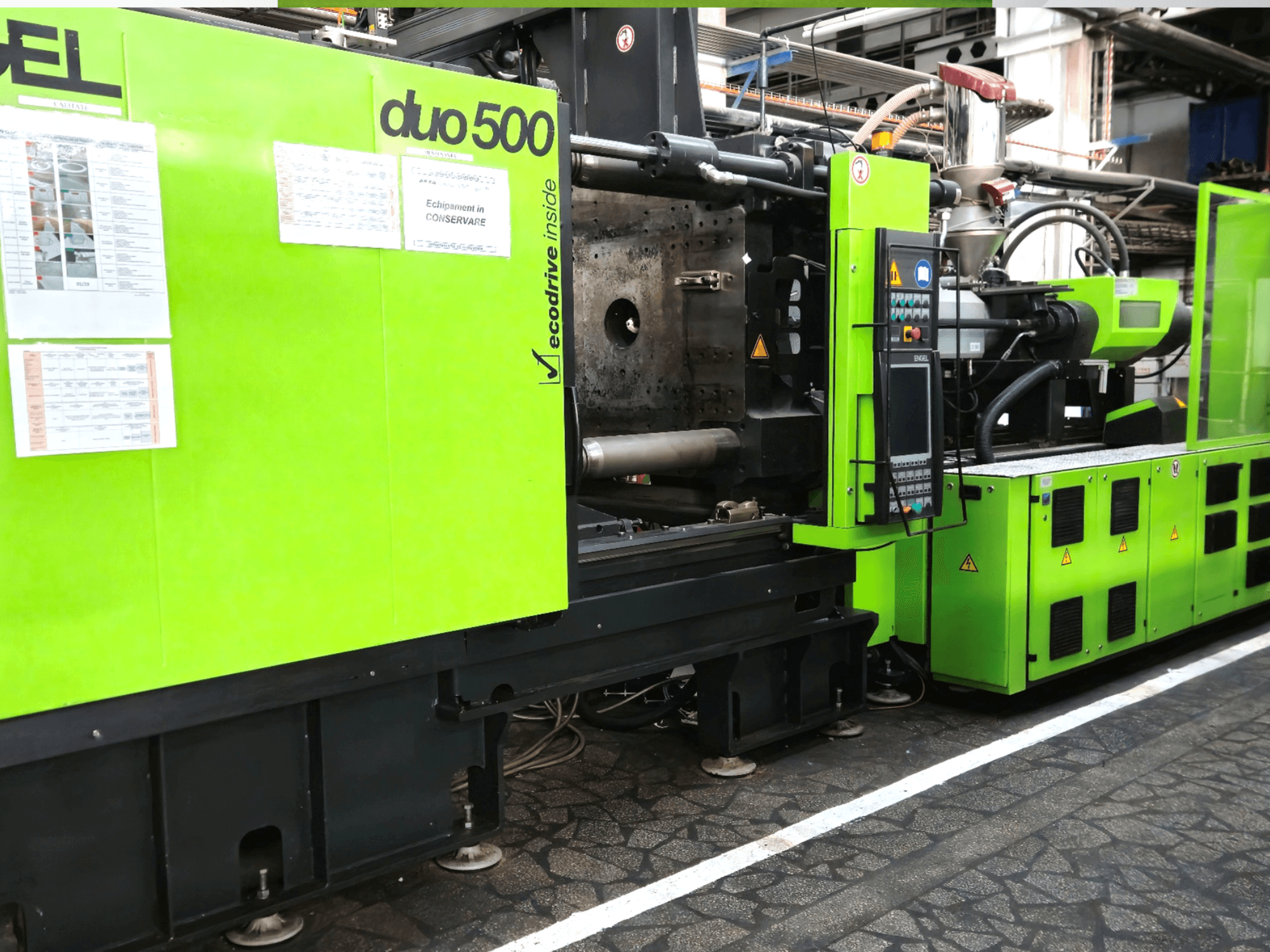 Yeşil endüstriyel makine Ergotron duo 500, önden görünüm; kontrol paneli, teknik detaylar ve ekipman güvenlik etiketleri.