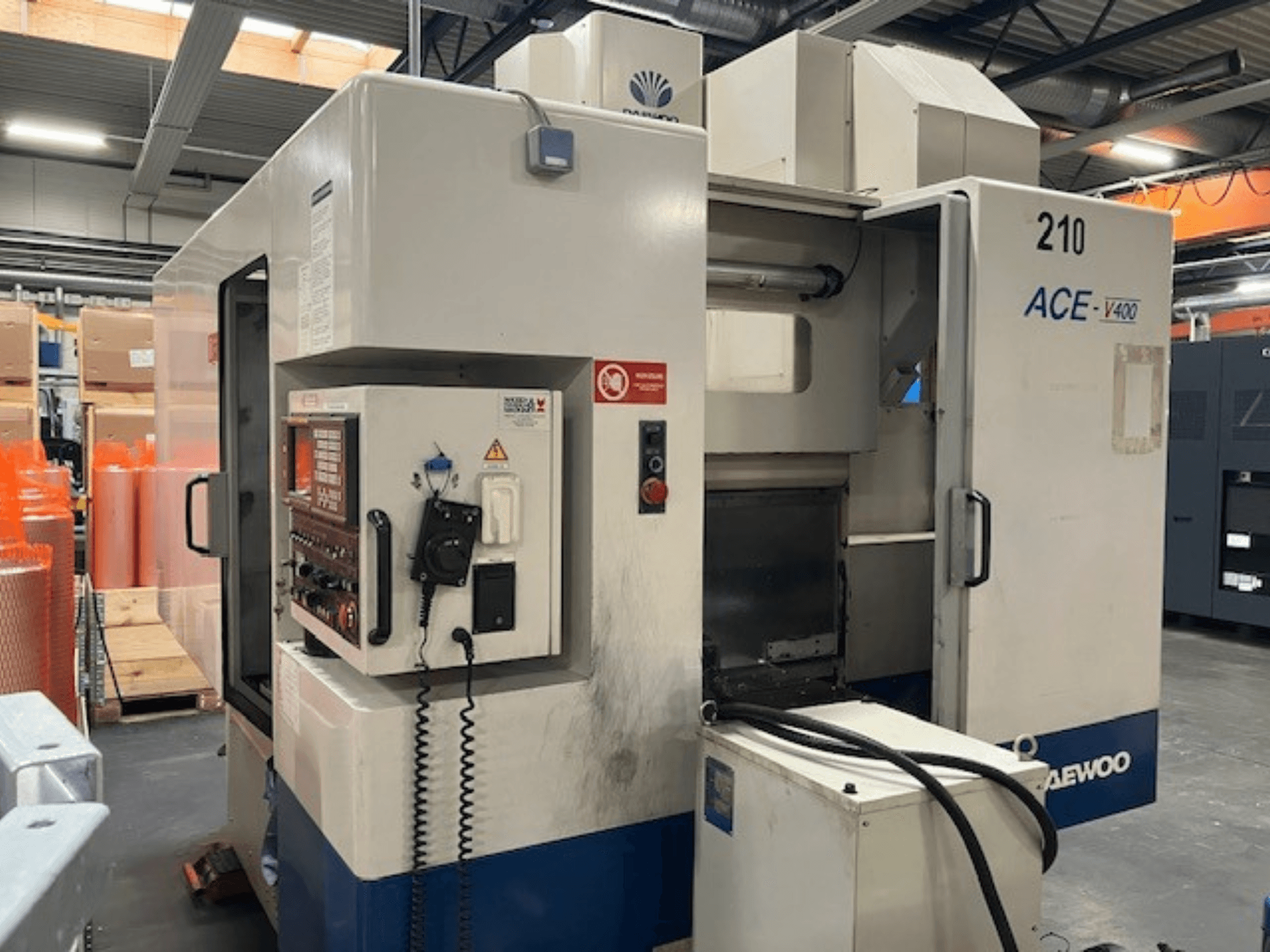 Daewoo ACE-V400 CNC makinesinin yandan görünümü, kontrol paneli, soğutucu tankı ve açık çalışma alanı.