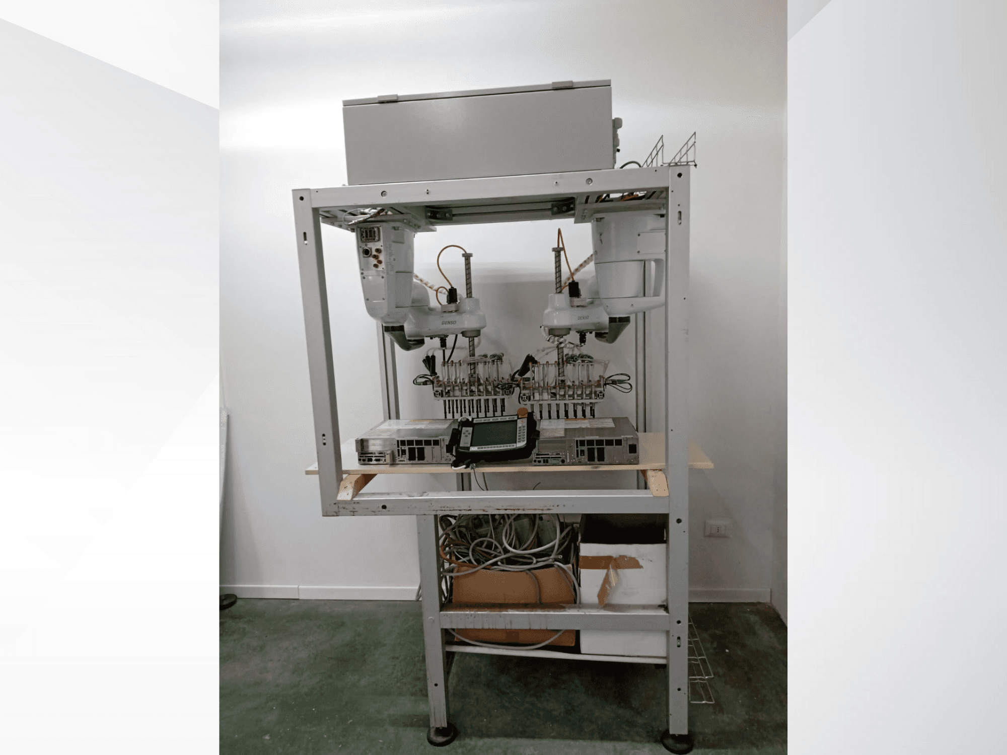 Çift kollu otomatik robotik iş istasyonu, ekran ünitesi ve metal çerçeve üzerinde elektronik aksam, önden görünüm, ileri teknoloji kurulumu.