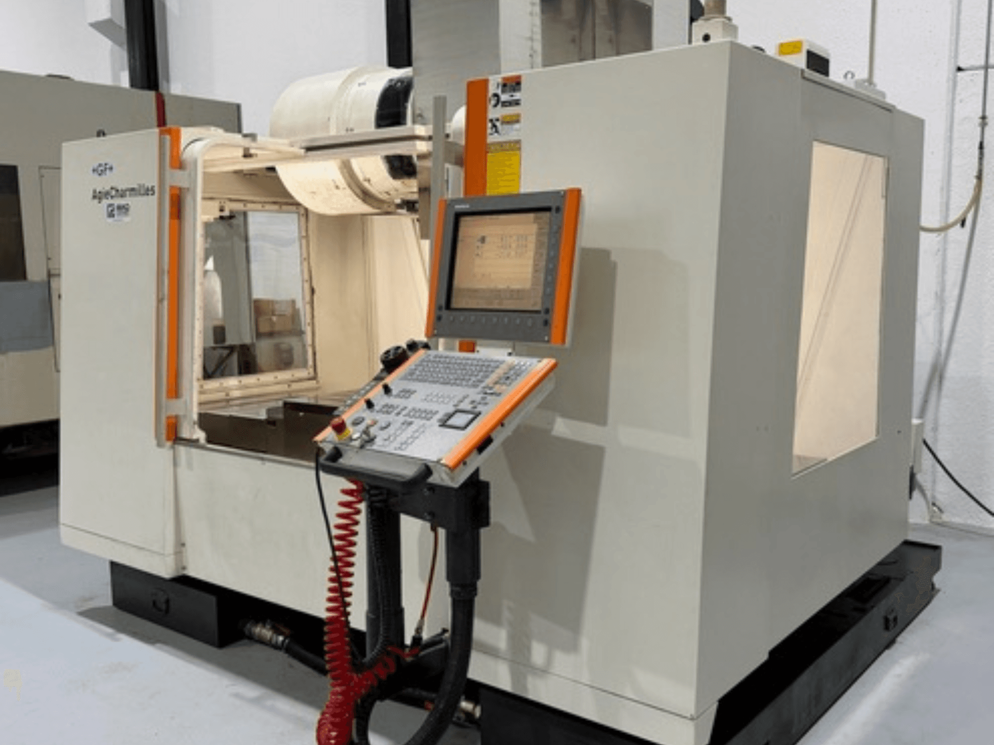 GF AgieCharmilles MIKRON freze makinesinin yandan görünümü, düğmeli bir kontrol paneline ve bir ekrana sahiptir.