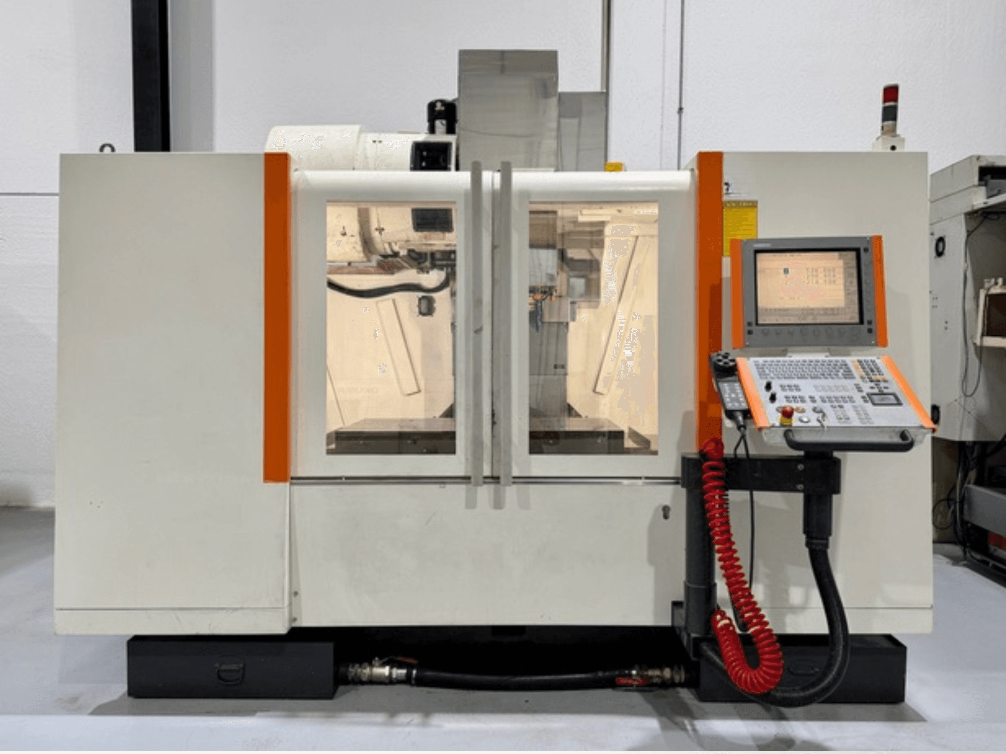 Turuncu desenli CNC makinesi, önden görünüm. Kontrol panelini ve görünür iç çalışmaları içerir.
