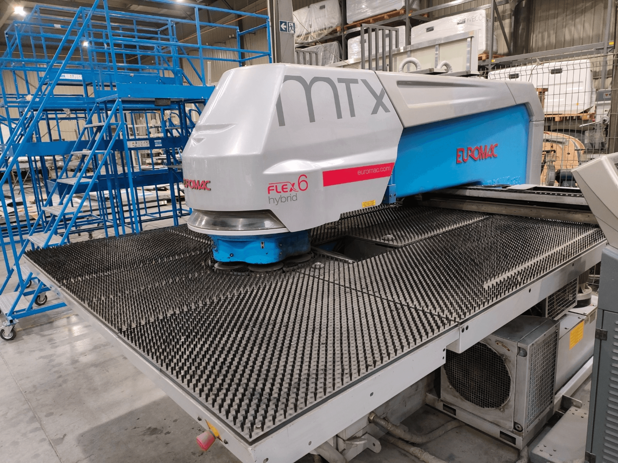 Dokulu kesme yüzeyine sahip bir Euromac FLEX 6 hibrit makinenin önden görünümü, bir depo ortamına yerleştirilmiştir.