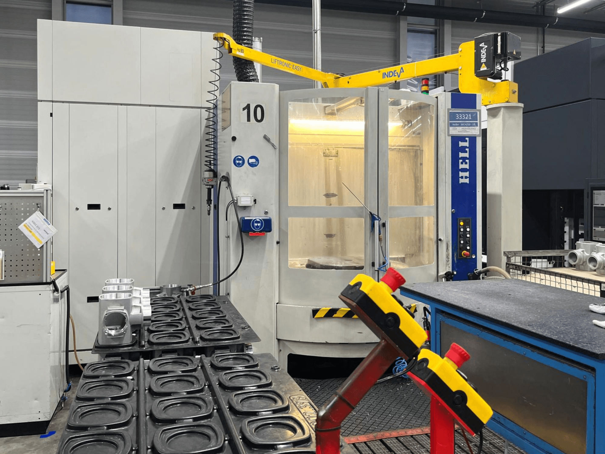 HELLER MCH 250 yatay işleme merkezi önden görünümde, alüminyum parçalar ve kontrol düğmeleri yandan görülebilir.