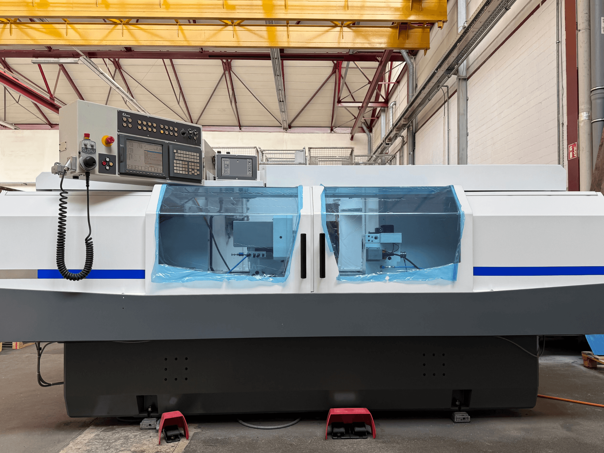 STUDER S33 CNC silindirik taşlama makinesinin yandan görünümü; kontrol paneli ve şeffaf güvenlik kapakları ile birlikte.