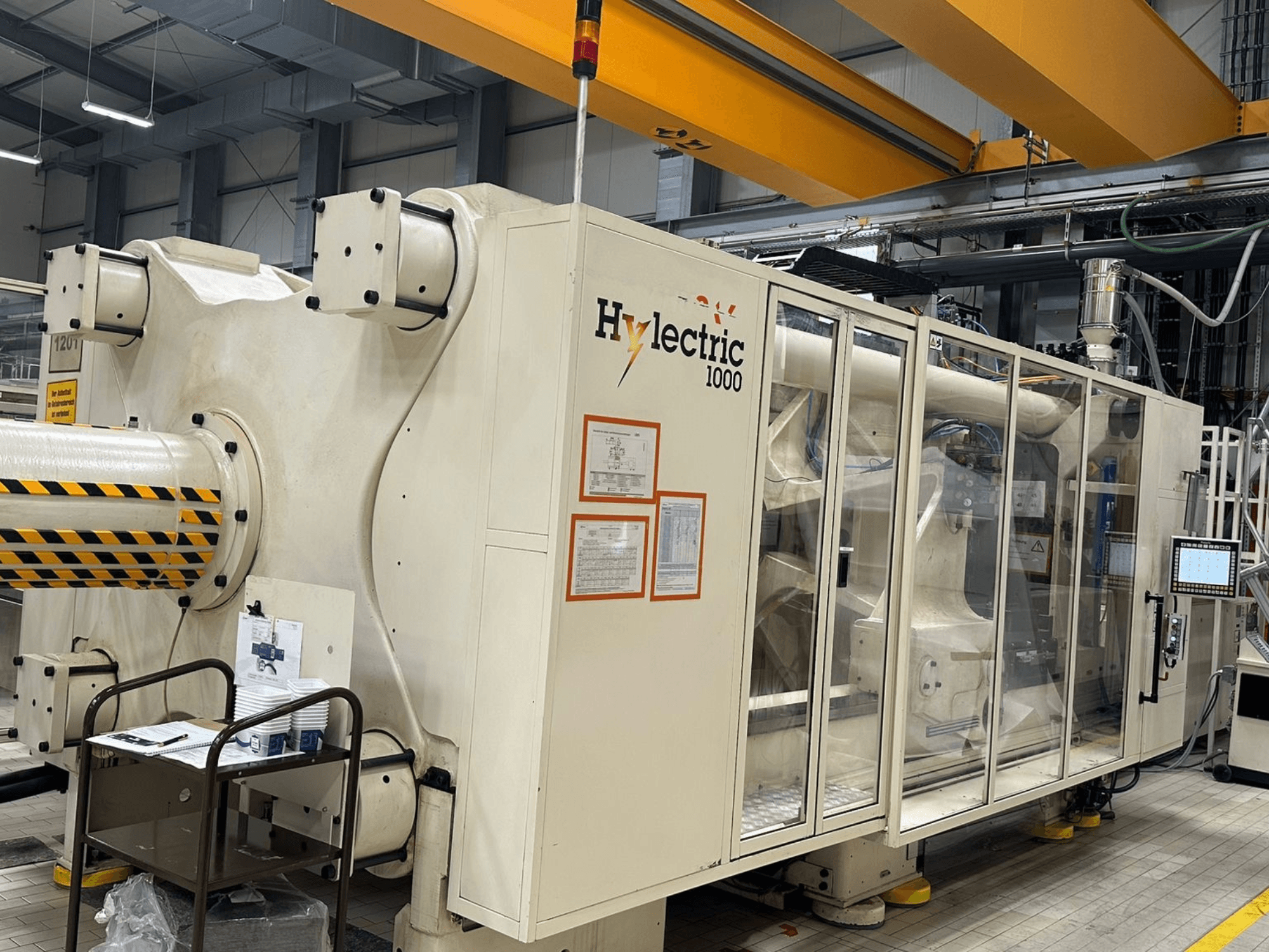 Husky Hylelectric H1000 RS95/80 elektrikli enjeksiyon kalıplama makinesi; kontrol paneli ve güvenlik özelliklerinin görüldüğü yan görünüm.