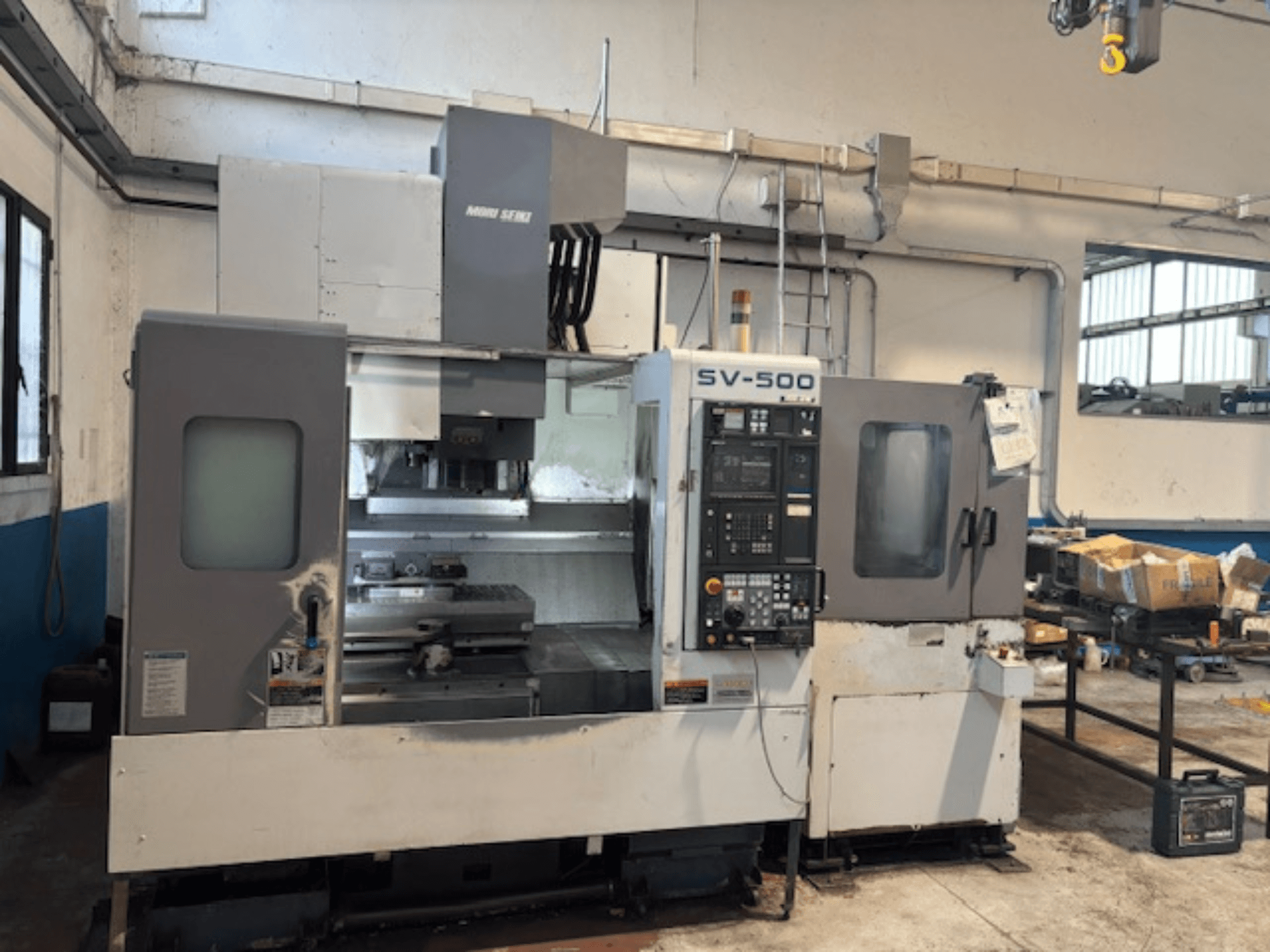 MORI SEIKI SV-500/40 dik işleme merkezi bir atölyede, kontrol paneli ve işleme alanını gösteren önden görünüm.