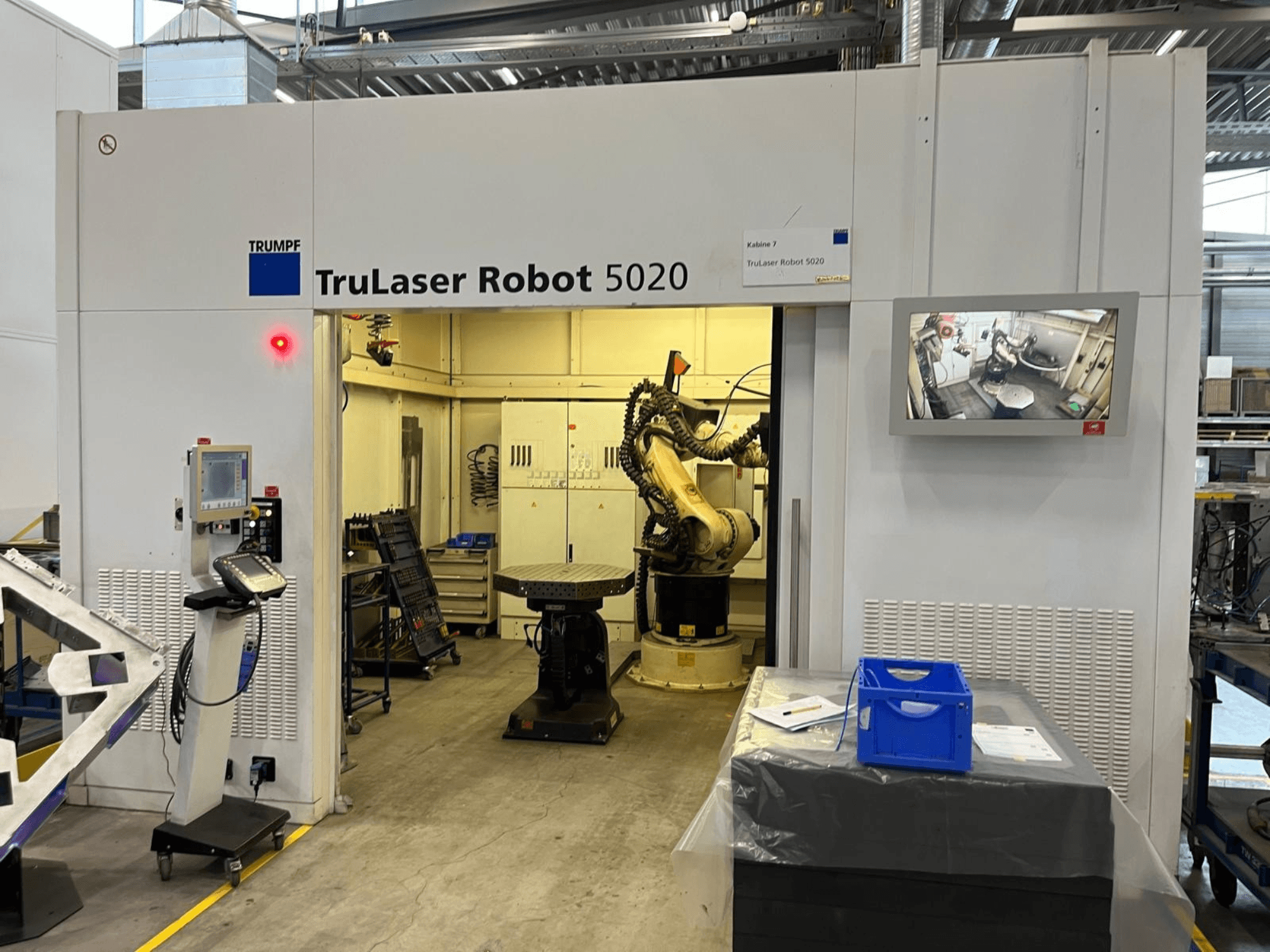 Endüstriyel bir ortamda bulunan TRUMPF TruLaser Robot 5020; kontrol paneli, robot kolu ve işlemleri gösteren bir monitör ile donatılmıştır.
