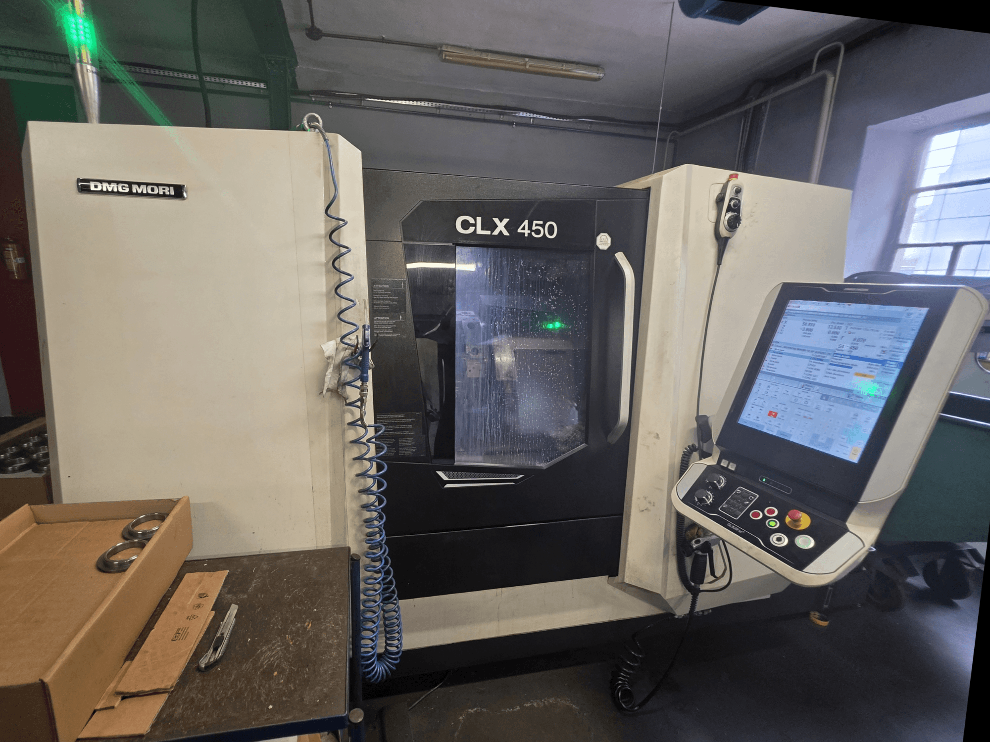 DMG MORI CLX 450 V3 yatay torna tezgahının, kontrol paneli, soğutma sıvısı sistemi ve çalışma alanını gösteren önden görünüşü.