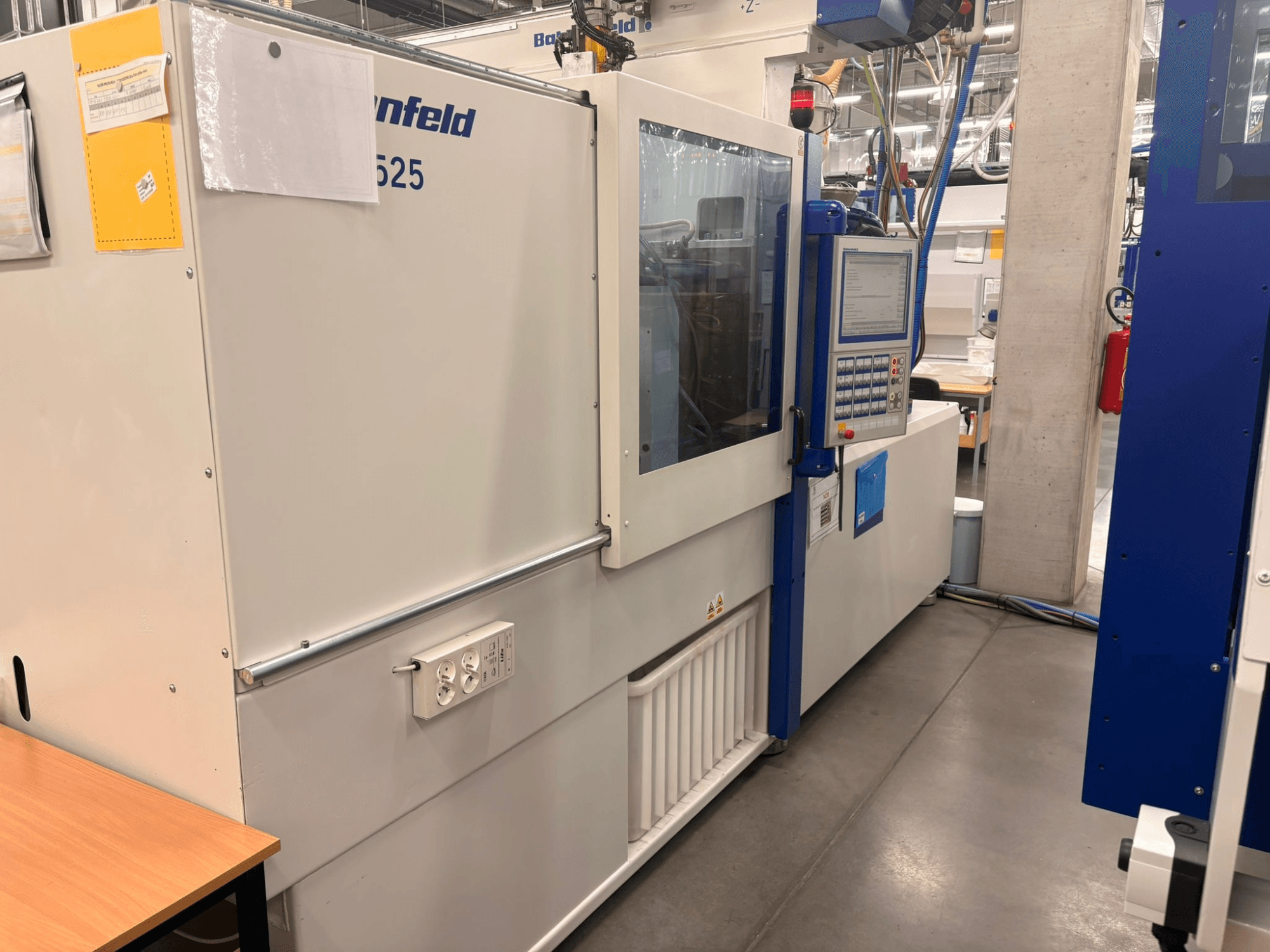 Arburg makineleri, model 620S, fabrika ortamında kontrol paneli ve güç bağlantı noktalarını gösteren önden görünüm.