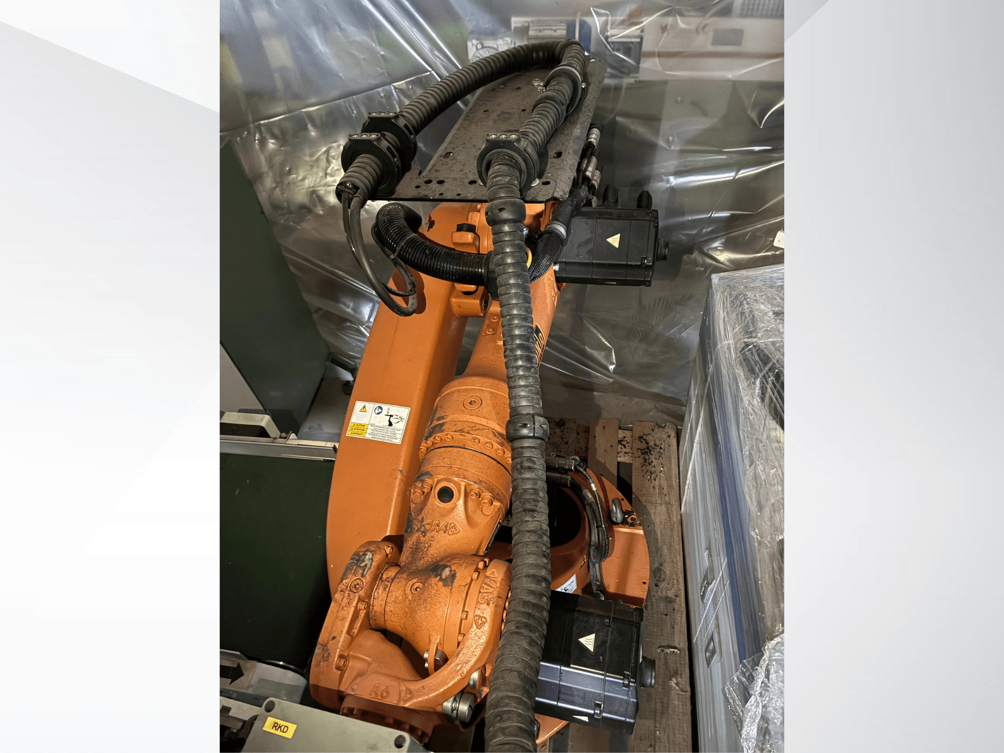 Turuncu renkli KUKA KR16-2 robot kolu, yukarıdan bakıldığında, konektörleri ve koruyucu boruları gösterilmektedir.