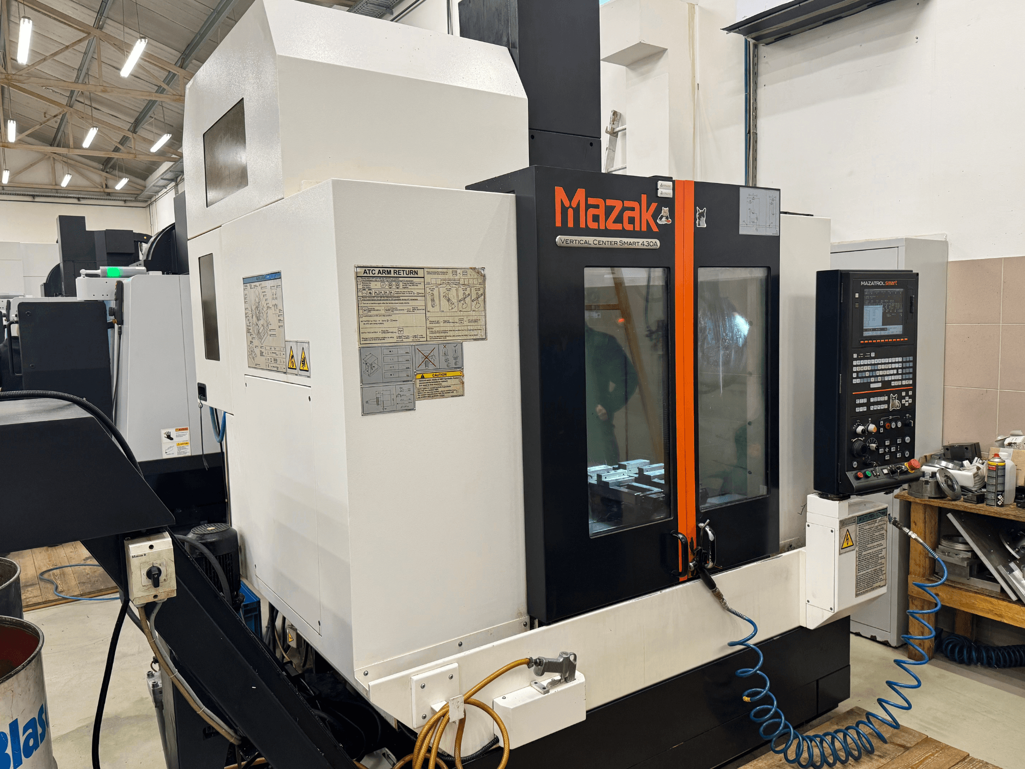 Mazak Dikey Merkez Smart 430A, önden görünüm; kontrol paneli, şeffaf muhafazası ve takım tutucusu görünen CNC freze makinesi.