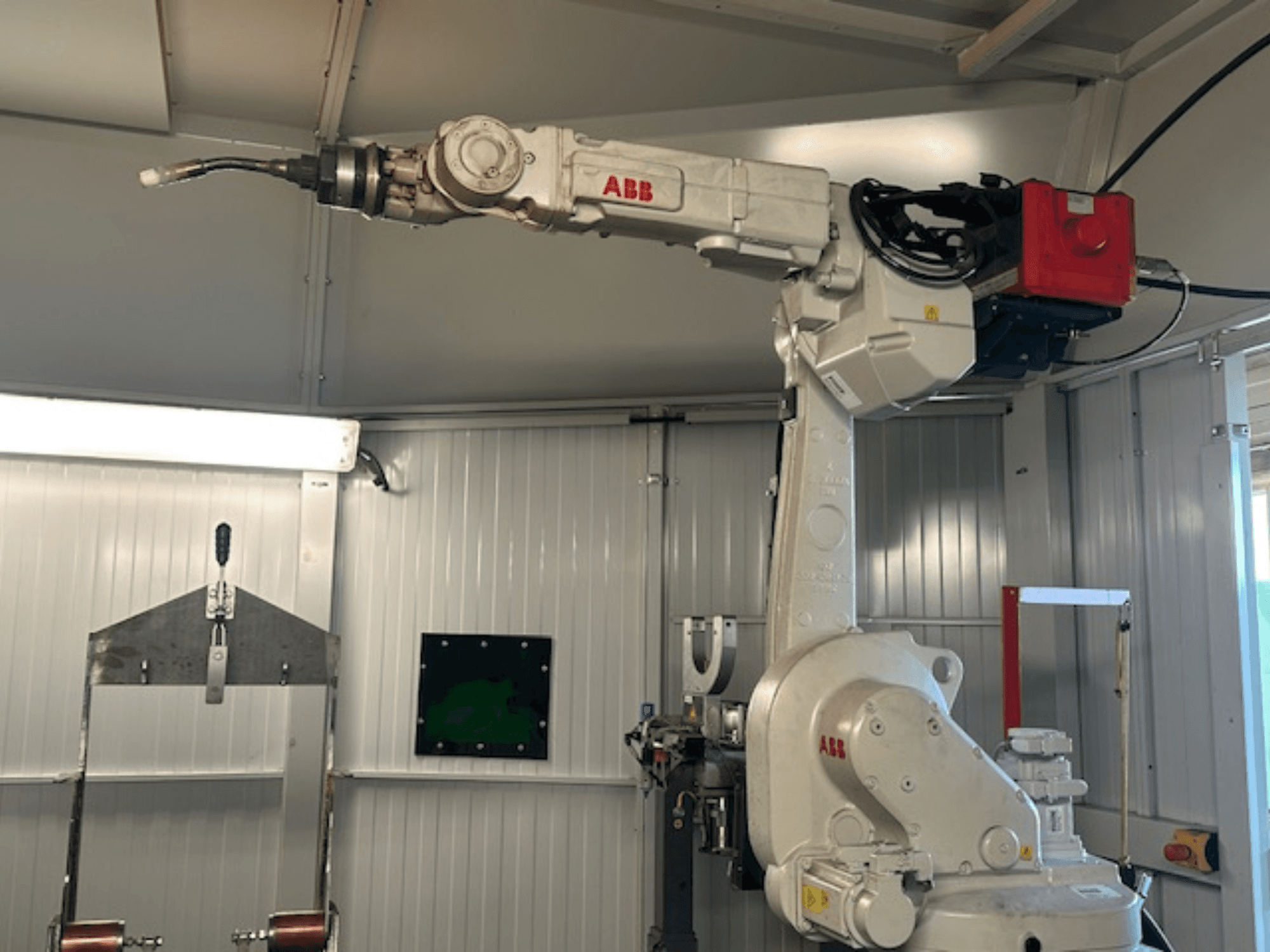 ABB Schweißroboter Flex Arc - kontrol paneli ve kablolar gibi ayrıntıları sergileyen kaynak aletli robotik kolun yandan görünümü.