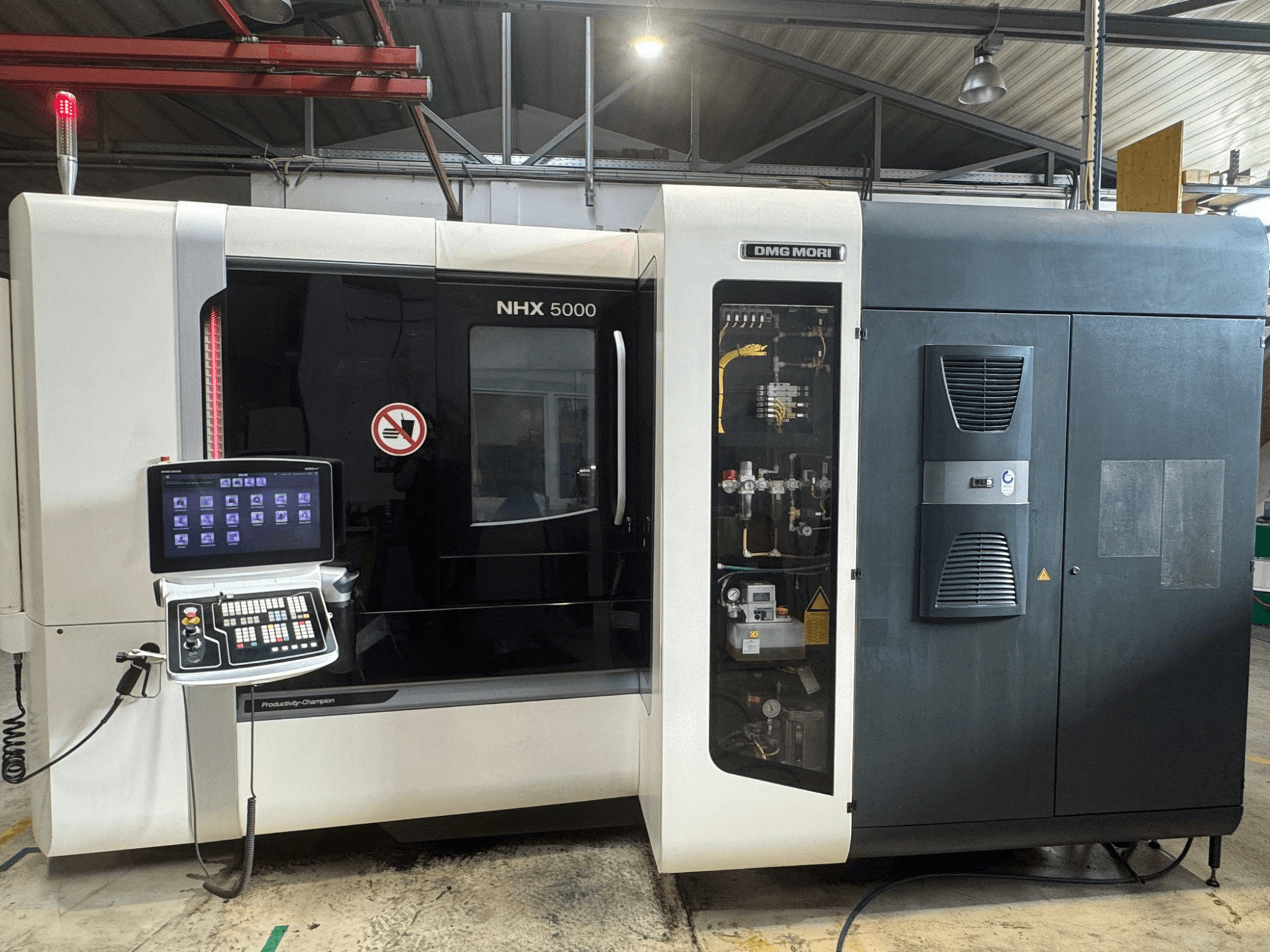 DMG MORI NHX 5000 yatay işleme merkezinin önden görünümü, kontrol panelini ve makine detaylarını gösterir.