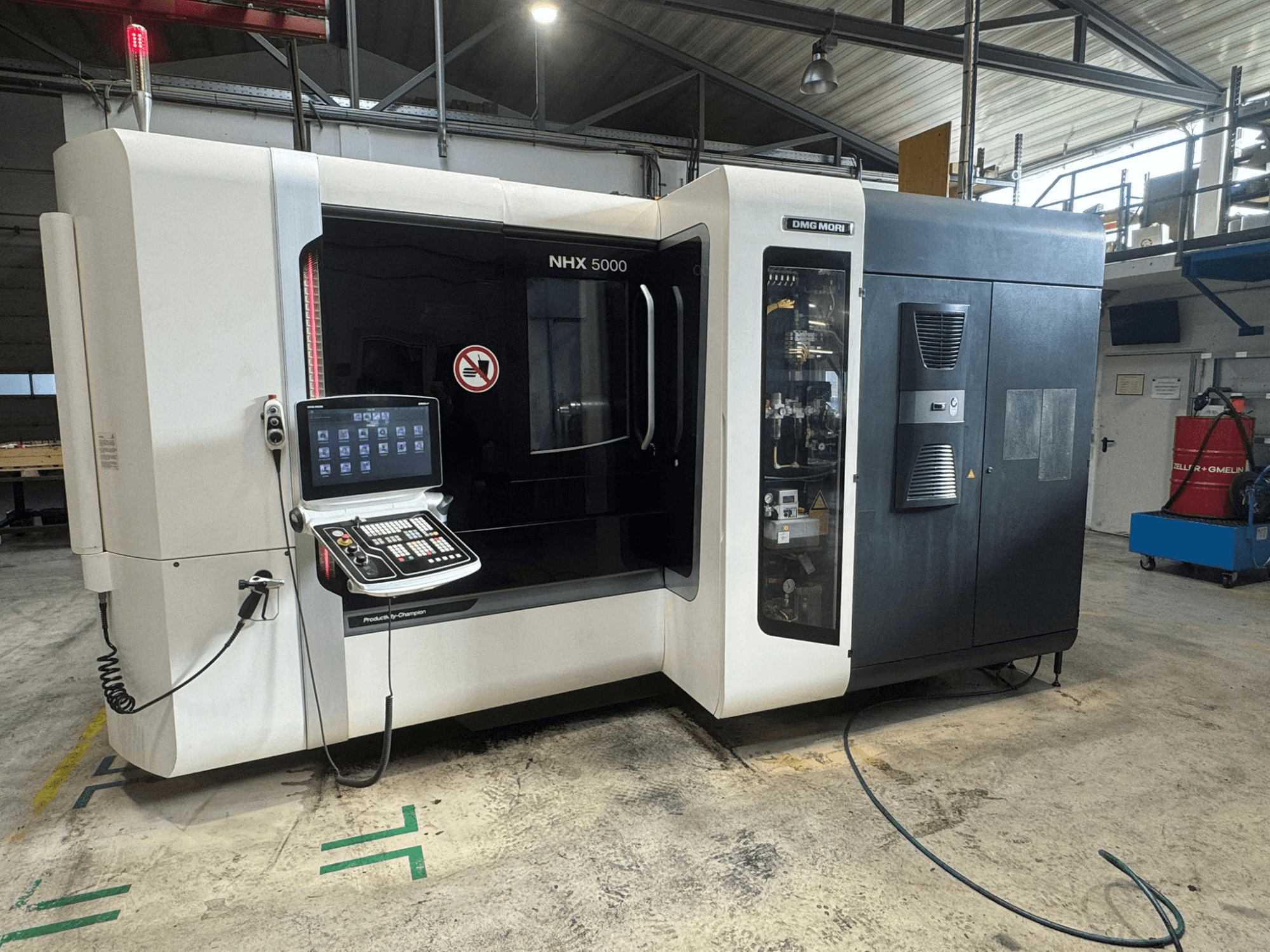 DMG MORI NHX 5000 yatay işleme merkezi, kontrol paneli görünür ve güvenlik göstergeleri ile önden görünüm.