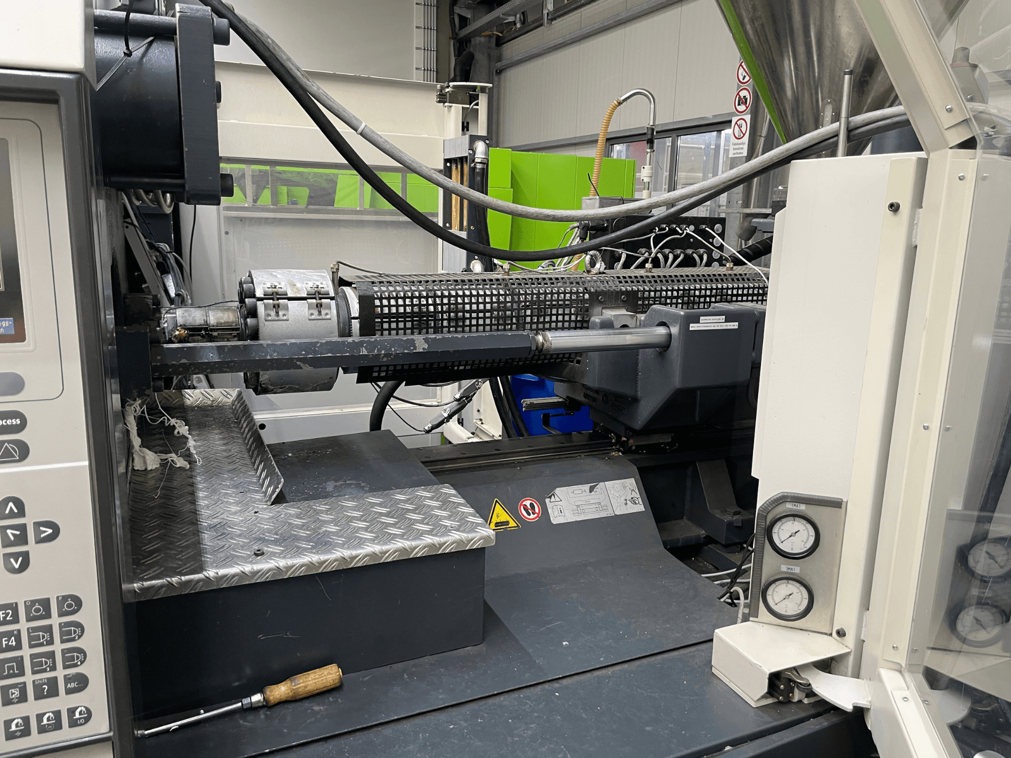 Kontrol paneli, ekstrüder ve basınç göstergelerinin görülebildiği enjeksiyon kalıplama makinesi yan görünümü, üretim görevleri için idealdir.