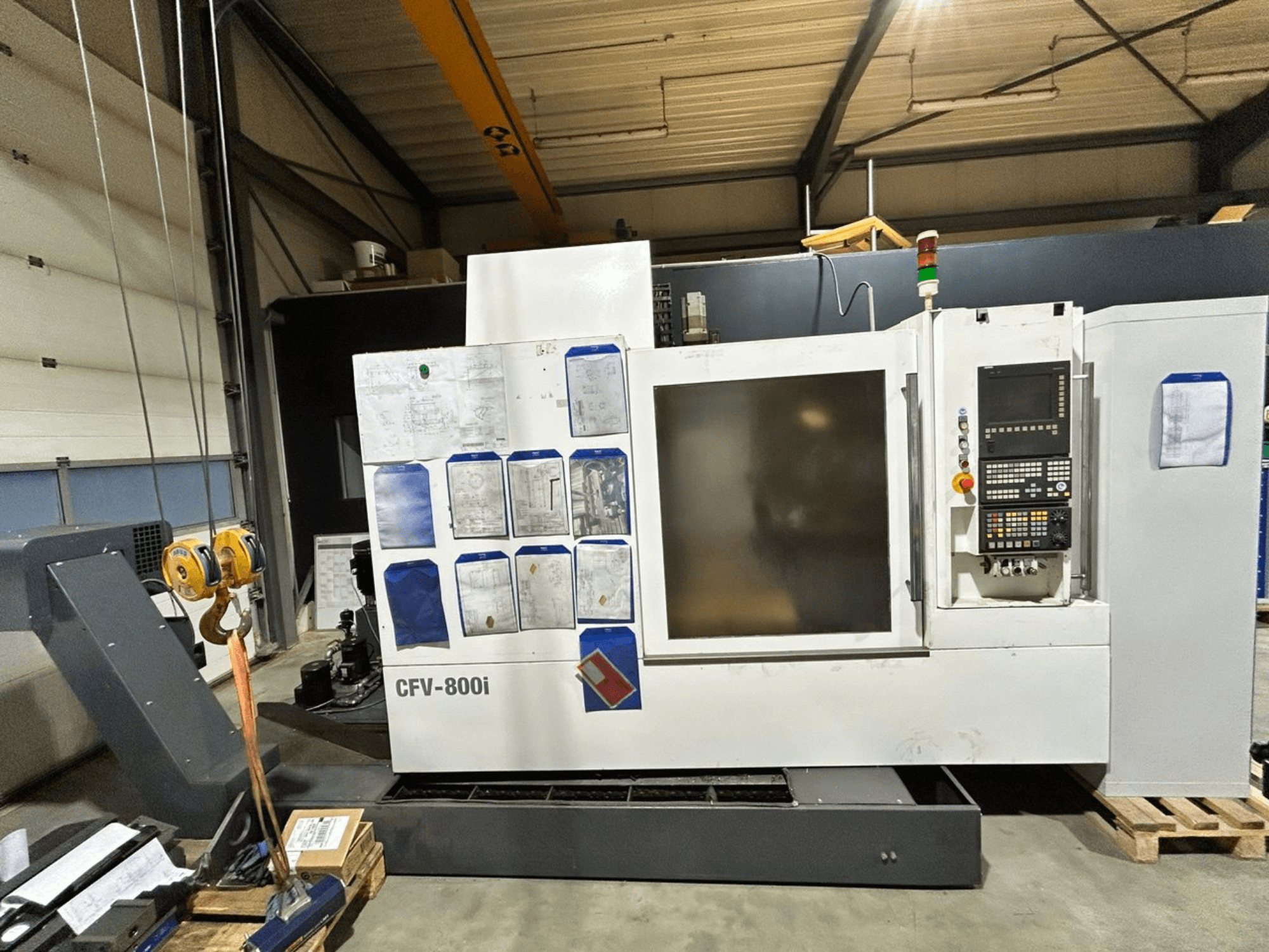 CFV-800i CNC makinesi önden görünümde, kontrol paneli, yanda belgeler ve fabrika ortamında tavan vinci ile gösterilmiştir.