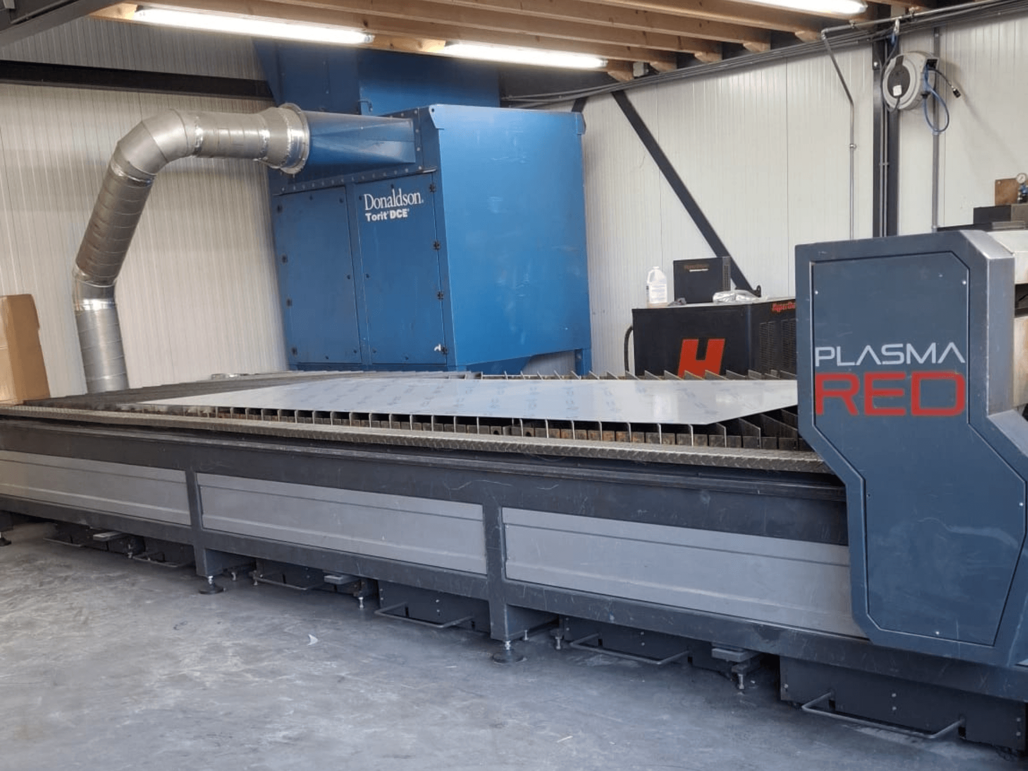 SOITAAB Plasmatech-Red plazma kesme makinesinin önden görünümü, geniş bir kesme tablası ve egzoz sistemine sahiptir.
