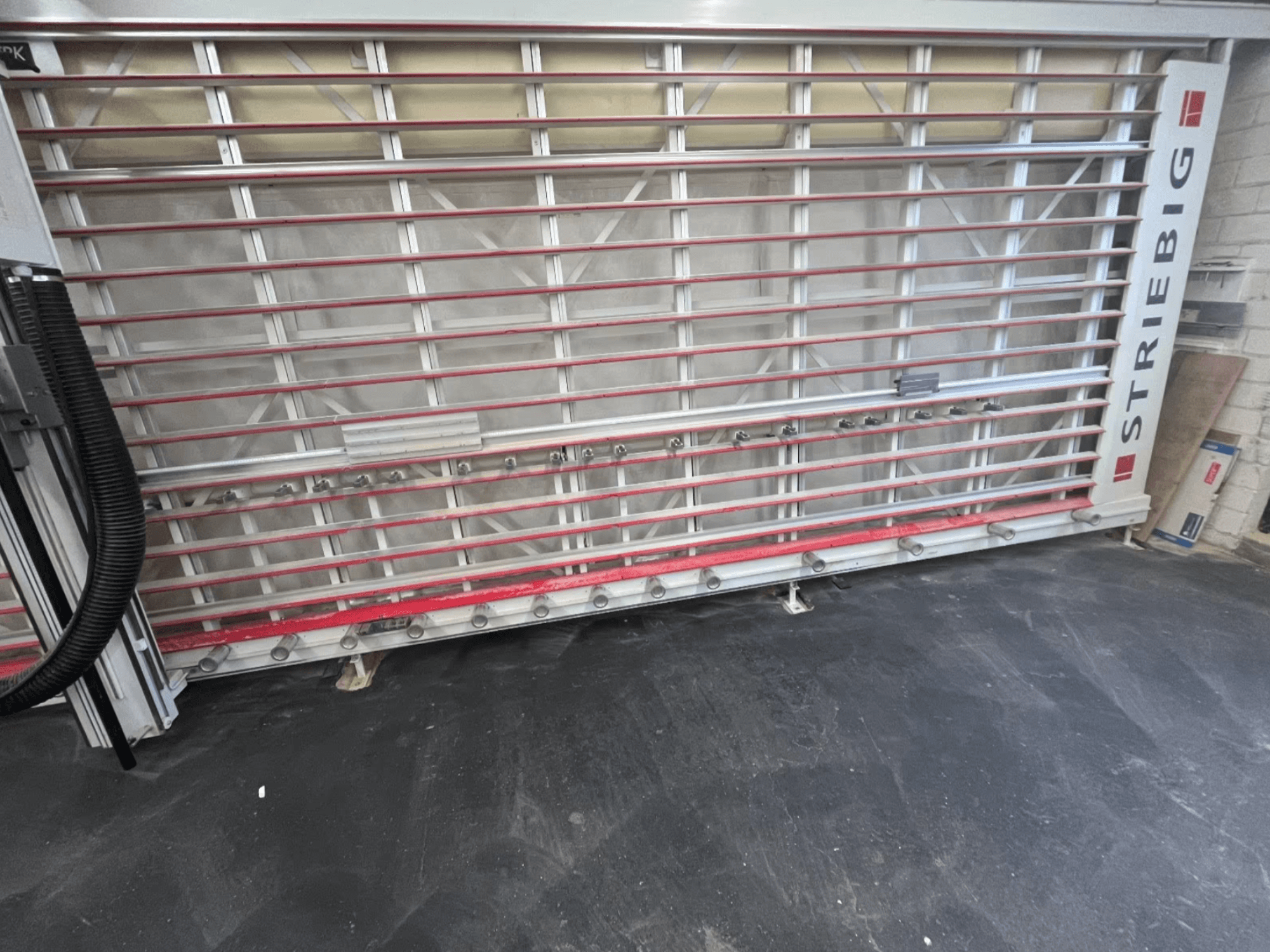 STRIEBIG Standart II TKR 6220A panel testere önden bakıldığında; kırmızı raylara ve kesme bileşenlerine sahip metal bir çerçeveye sahiptir.