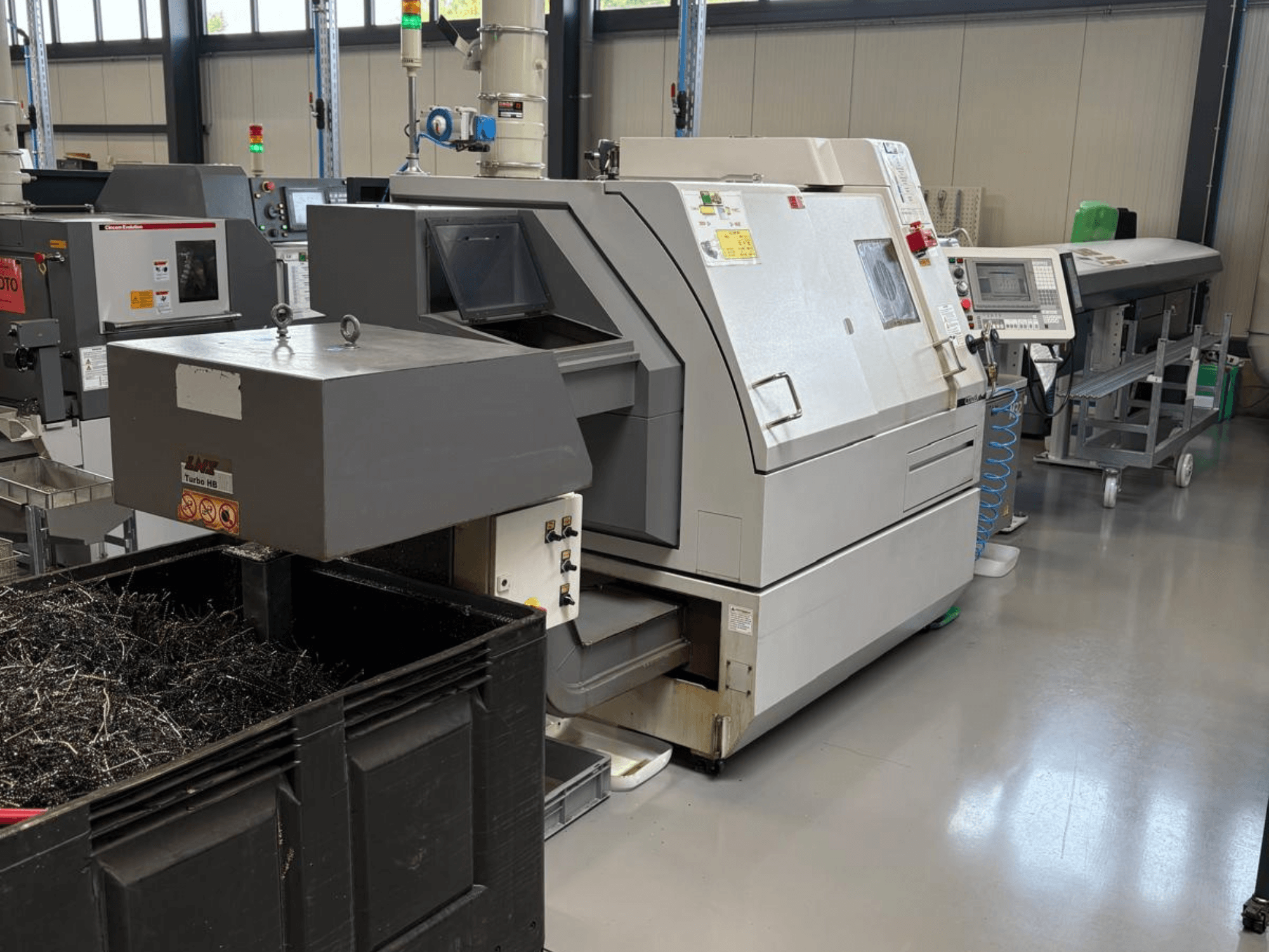 LTA Turbo H8 endüstriyel makine, yandan görünüm, metal talaşı için büyük bir konteyner ve fabrika ortamında kontrol paneli ile.