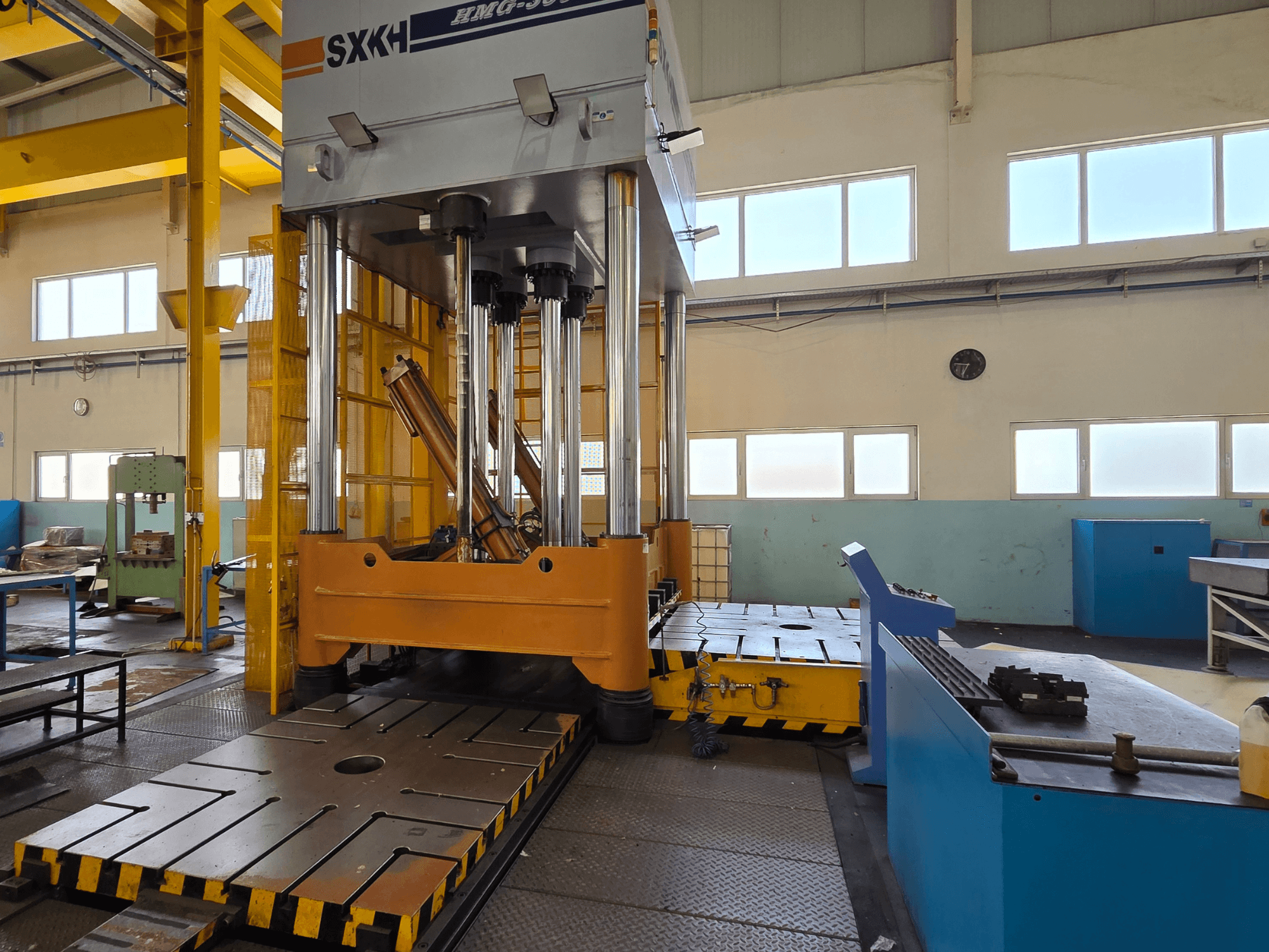 Fabrika ortamında büyük presleme silindirleri ve sağlam bir tabana sahip hidrolik pres SXKH HMG-300JM önden görünüm.